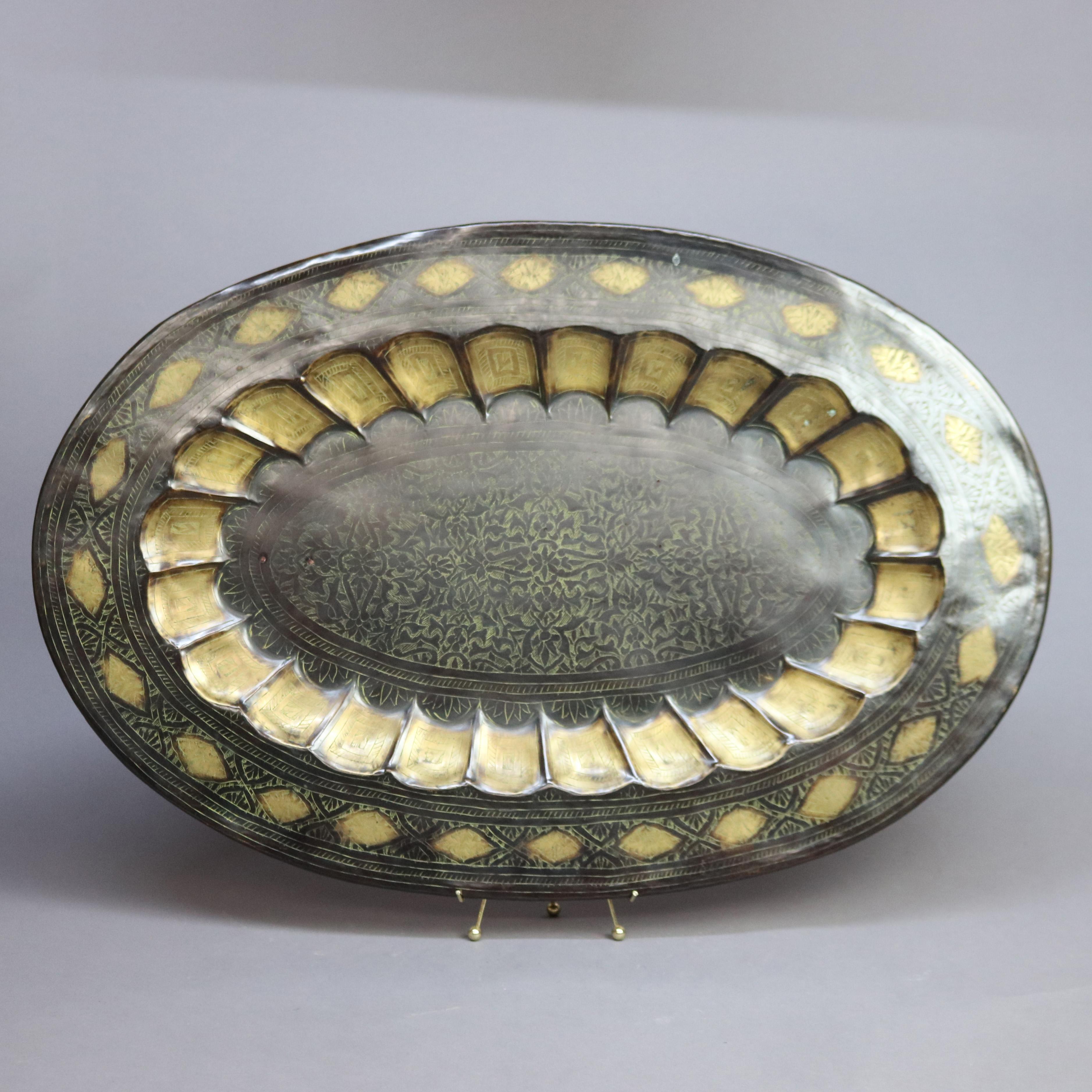 An orientalist brass oversized tray offers scalloped rim and incised decoration in bowl, 20th century

Measures - 34.5