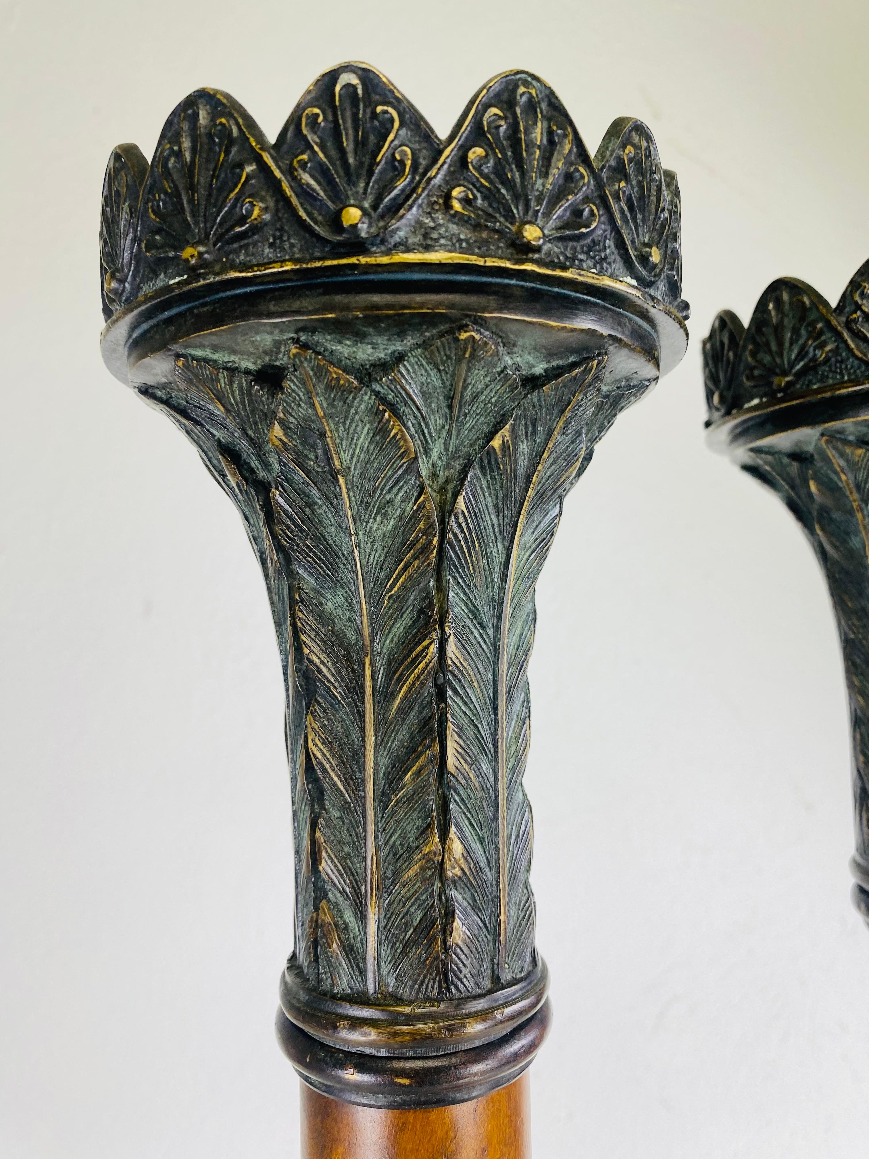 This is a pair of vintage oversized candlesticks after Theodore Alexander. These candlesticks have bronze Lyon feet and a burled walnut columns. At the top the bronze candleholder has a leaf design with an architectural edge. This exceptional pair