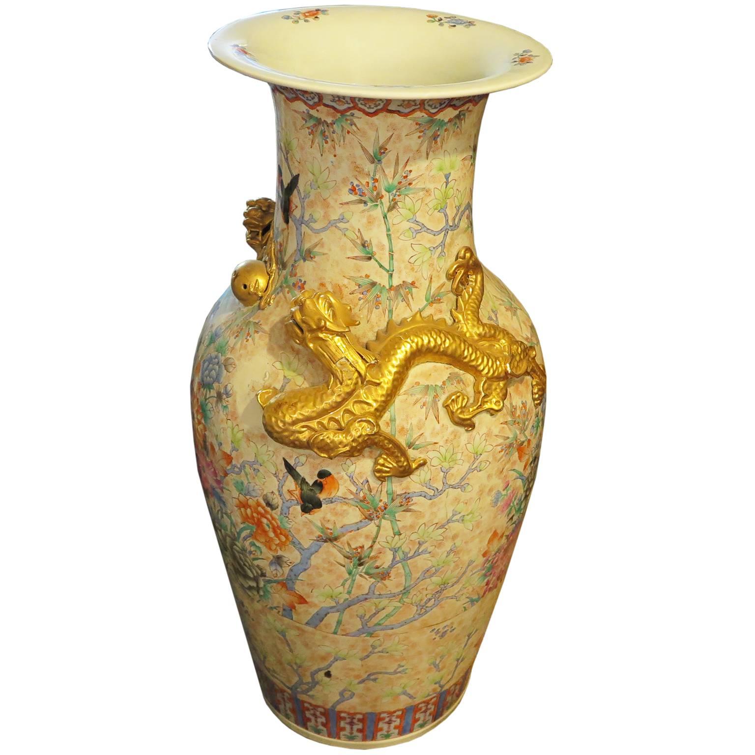 Extra large Cantonese porcelain urn vase from the late 19th century. The vase is hand-painted and depicts scenes of flowers and birds in a nature motif. The sides of the vase are adorned with two golden dragons.
 