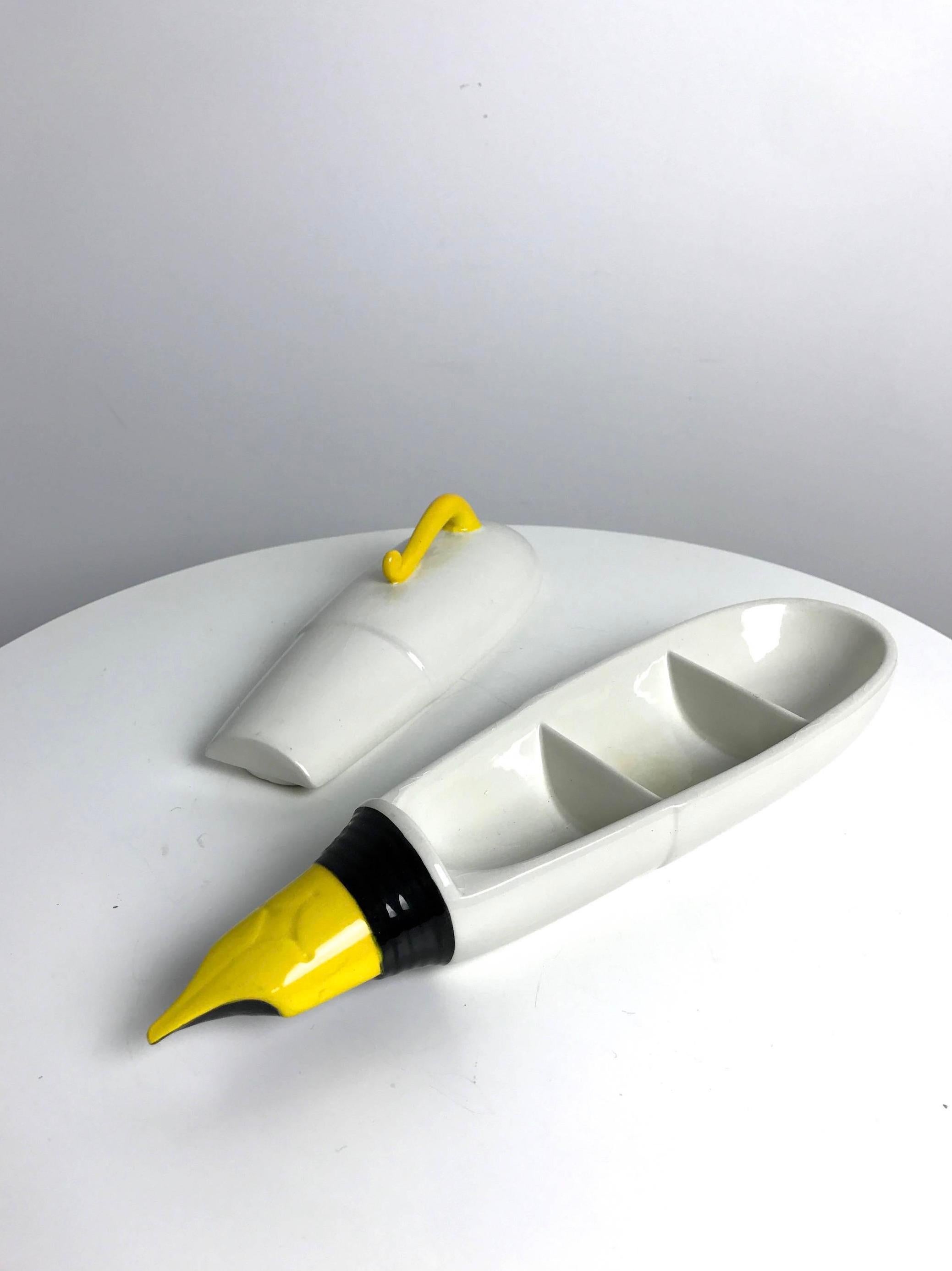 Fantastic oversized ceramic box in the shape of a fountain pen by Raymor. Lid opens up to display three separate storage compartments. White ceramic box with yellow clip and yellow and black fountain tip. Original Raymor label and Made in Italy on