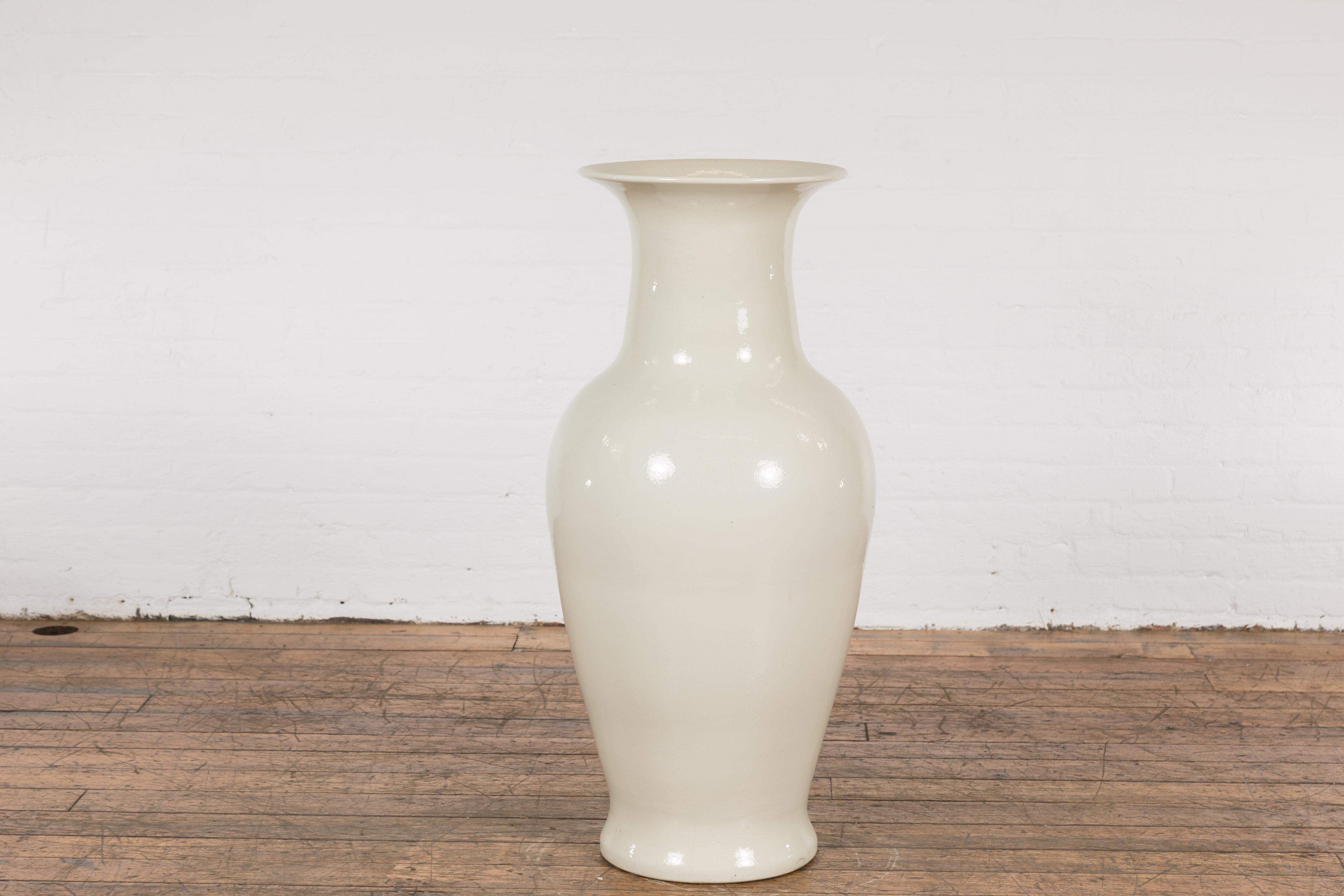 An oversized Chinese vintage blanc de Chine altar vase from the mid 20th century, with discreet crackle finish and flaring neck. Created in China during the midcentury period, this large vase features a tall neck supporting a flaring neck (with a