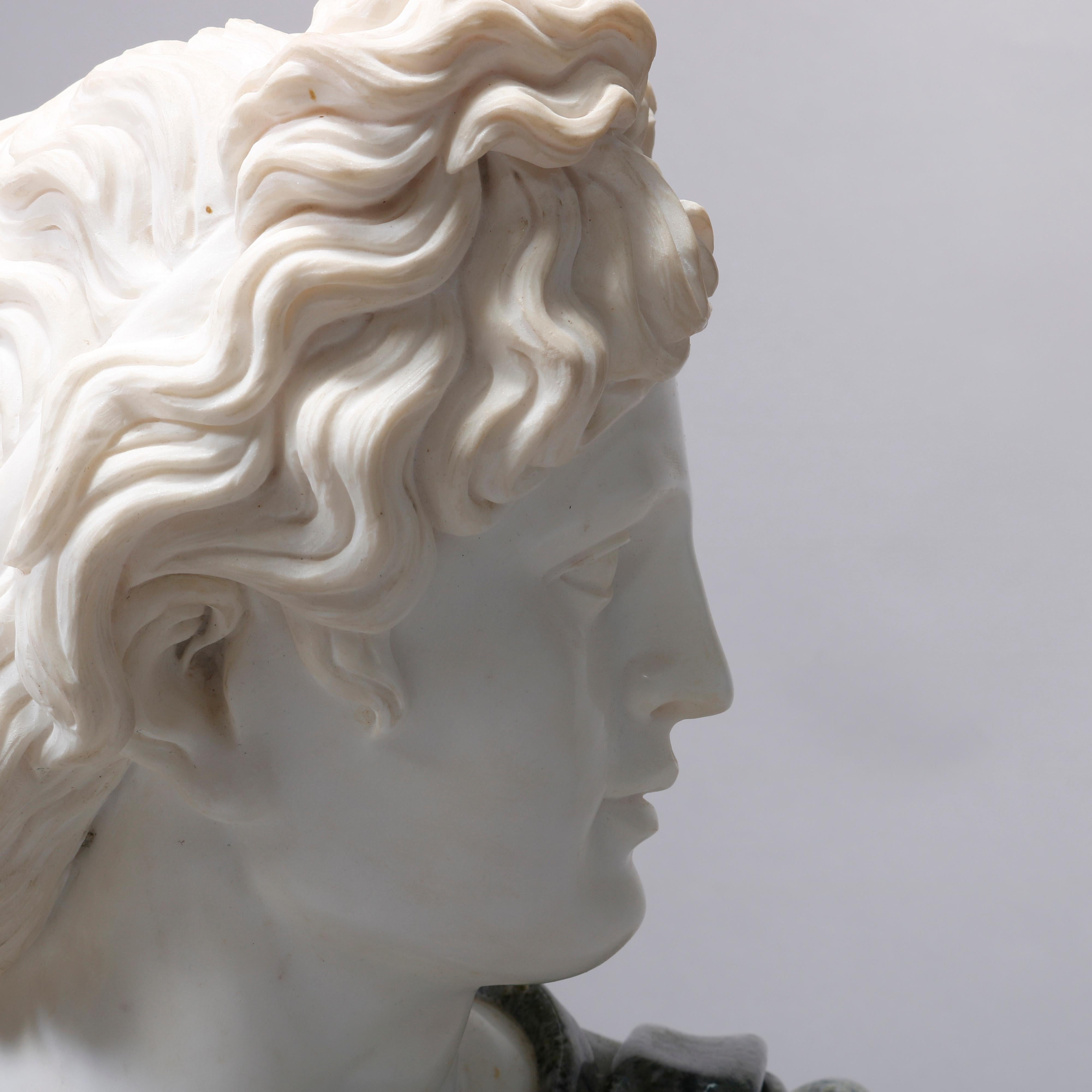 An oversized Italian carved marble portrait sculpture depicts the classical Greek bust of Apollo Belvedere after  after Leochares, seated on round plinth, 20th century

Measures: 25