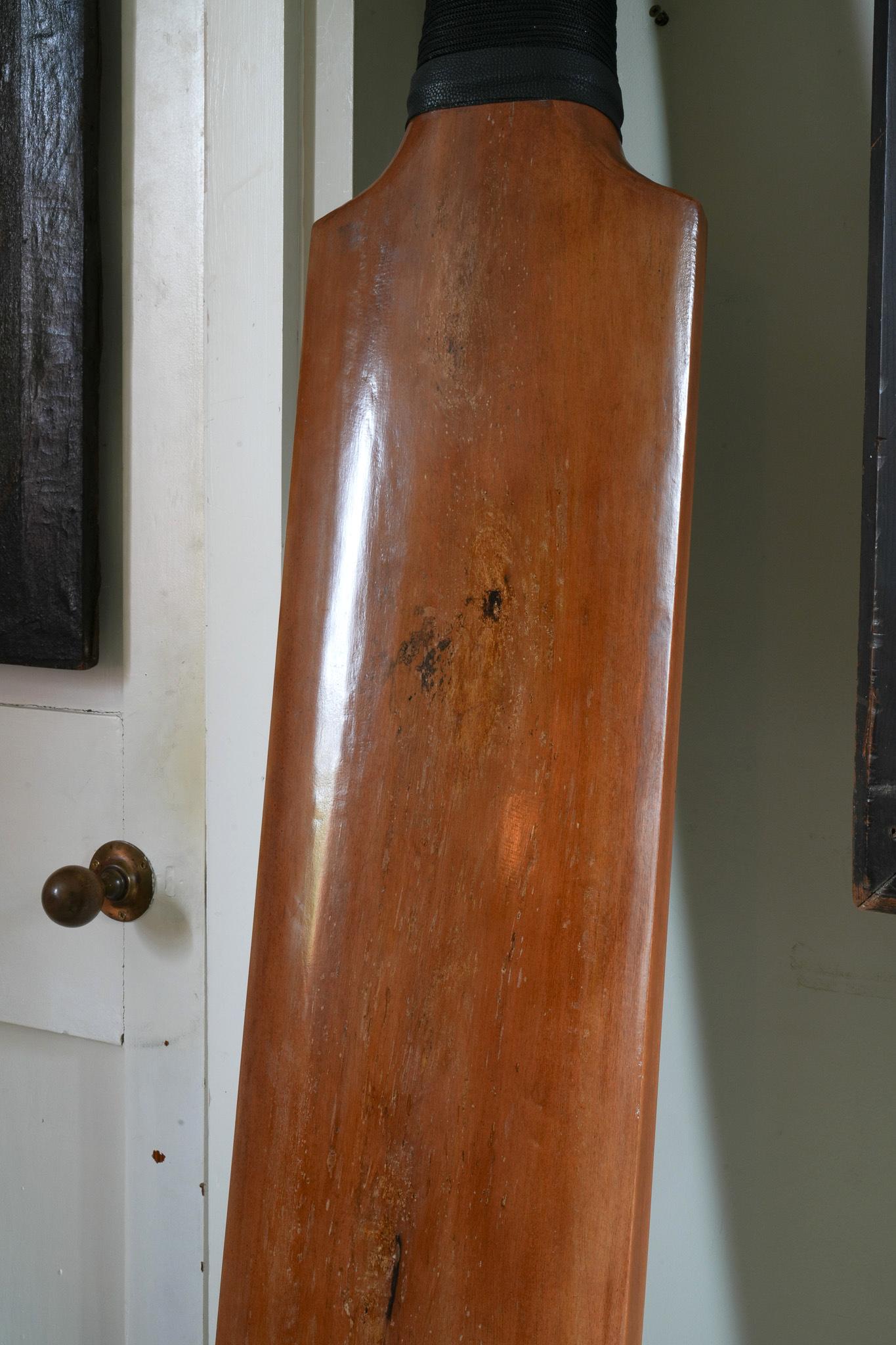 An extraordinary one off over-sized cricket bat, polished teak with a string-bound handle. 