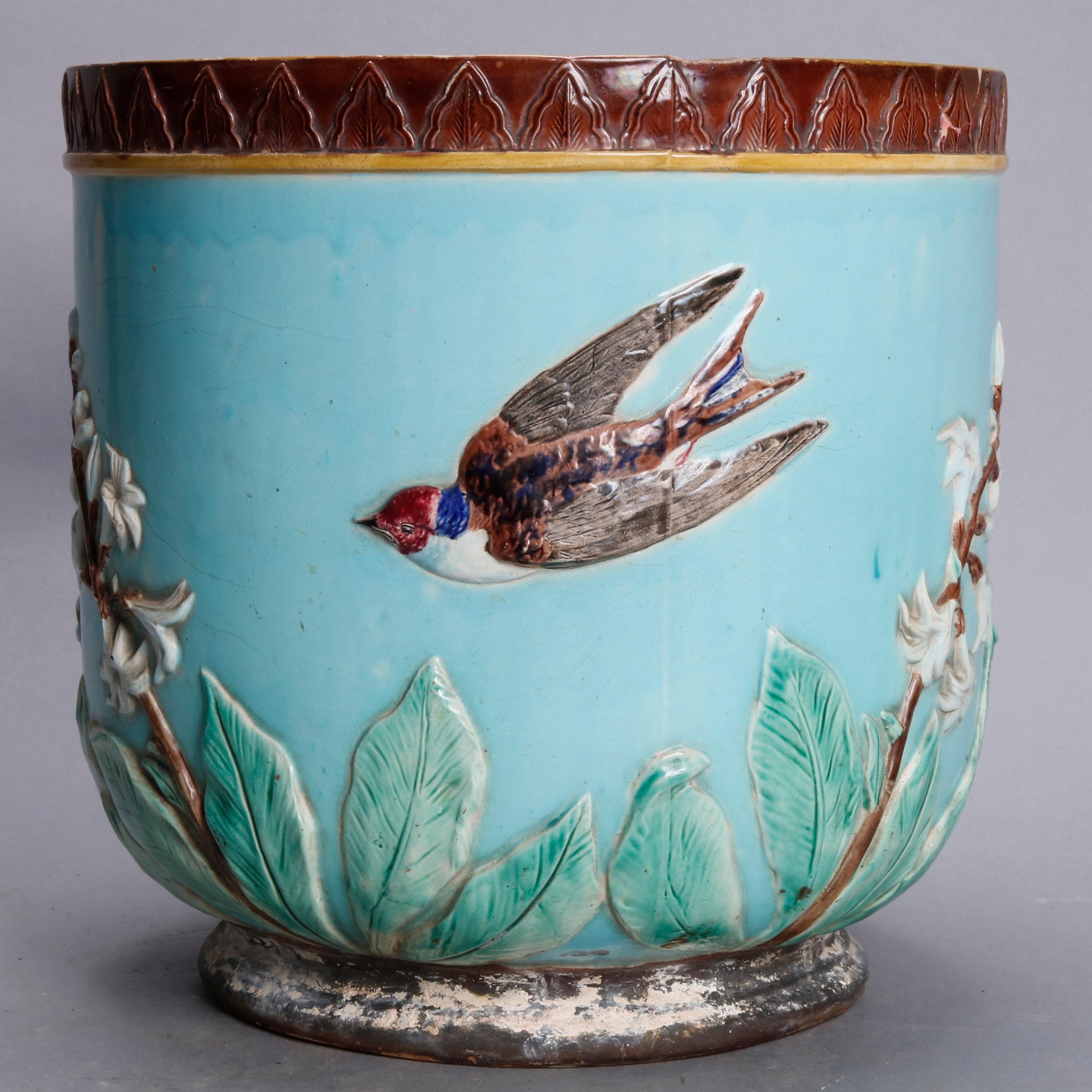 An antique English Aesthetic Movement Wedgwood Majolica pottery oversized jardinière offers garden or marsh scene with swallows (birds) in flight on turquoise ground, circa 1870.

Measures: 12.5