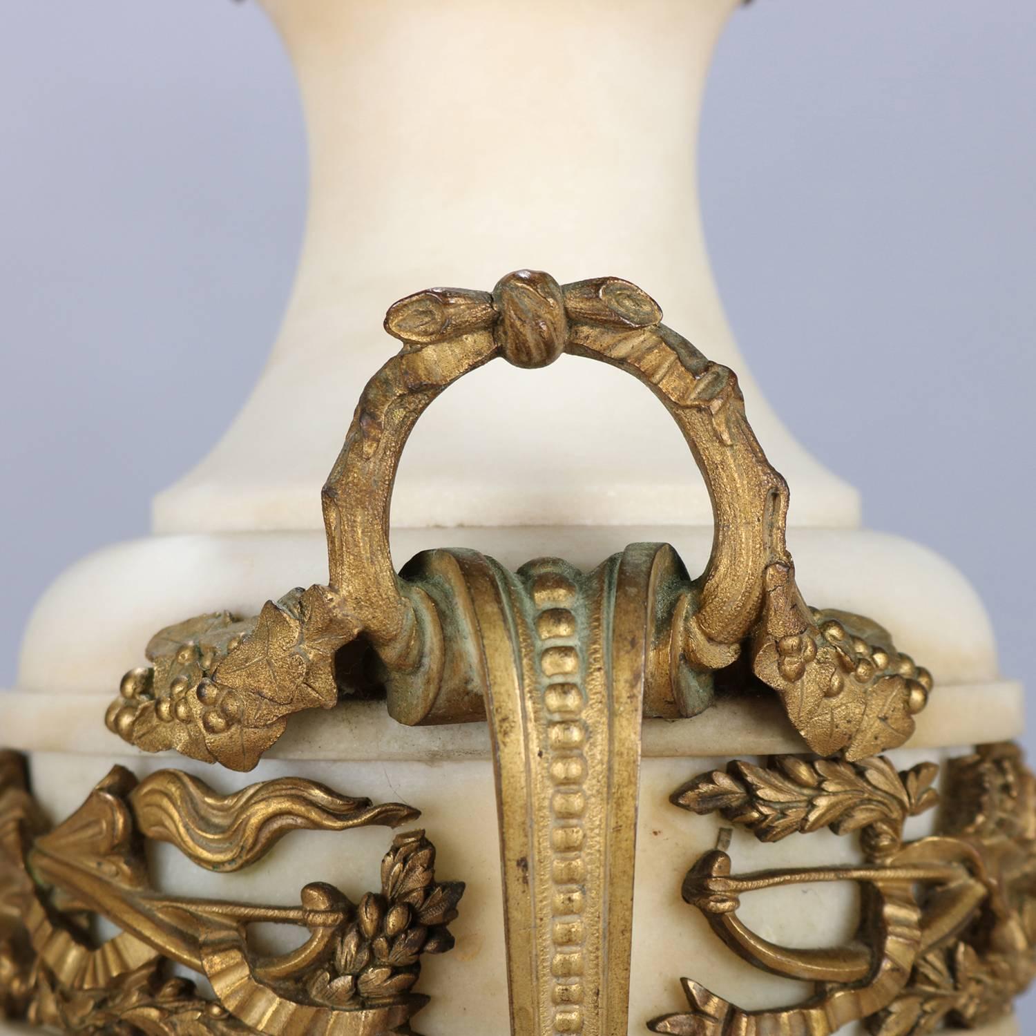 Pair of oversized French Classical candelabra feature urn form with gilt bronze mounts including five scroll and foliate form branch arms with central flame finial, two laurel wreath form handles, upper band is pierced with Victory torch and floral