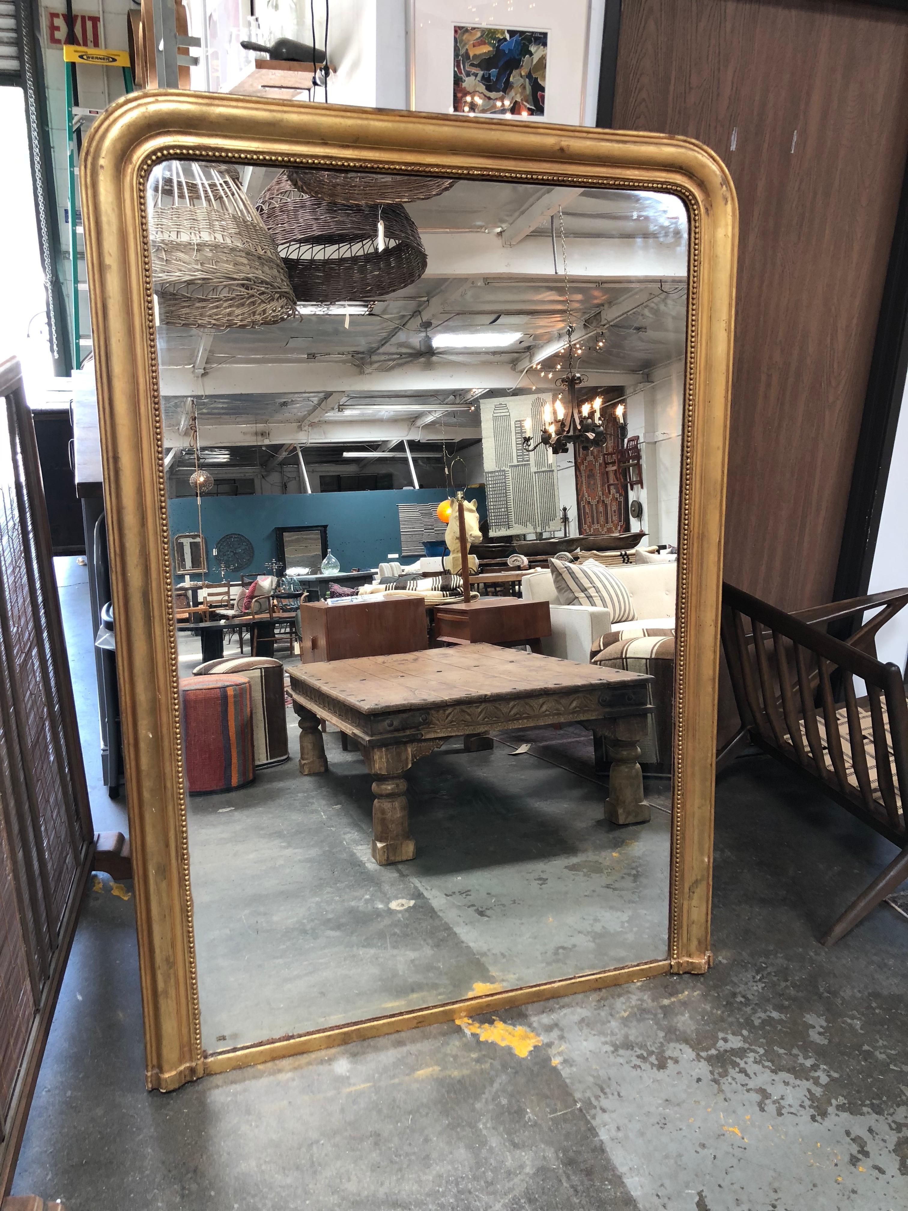Beautiful vintage antique bronze gilded mirror with hanging wire hardware. 
A great statement piece for any large space!