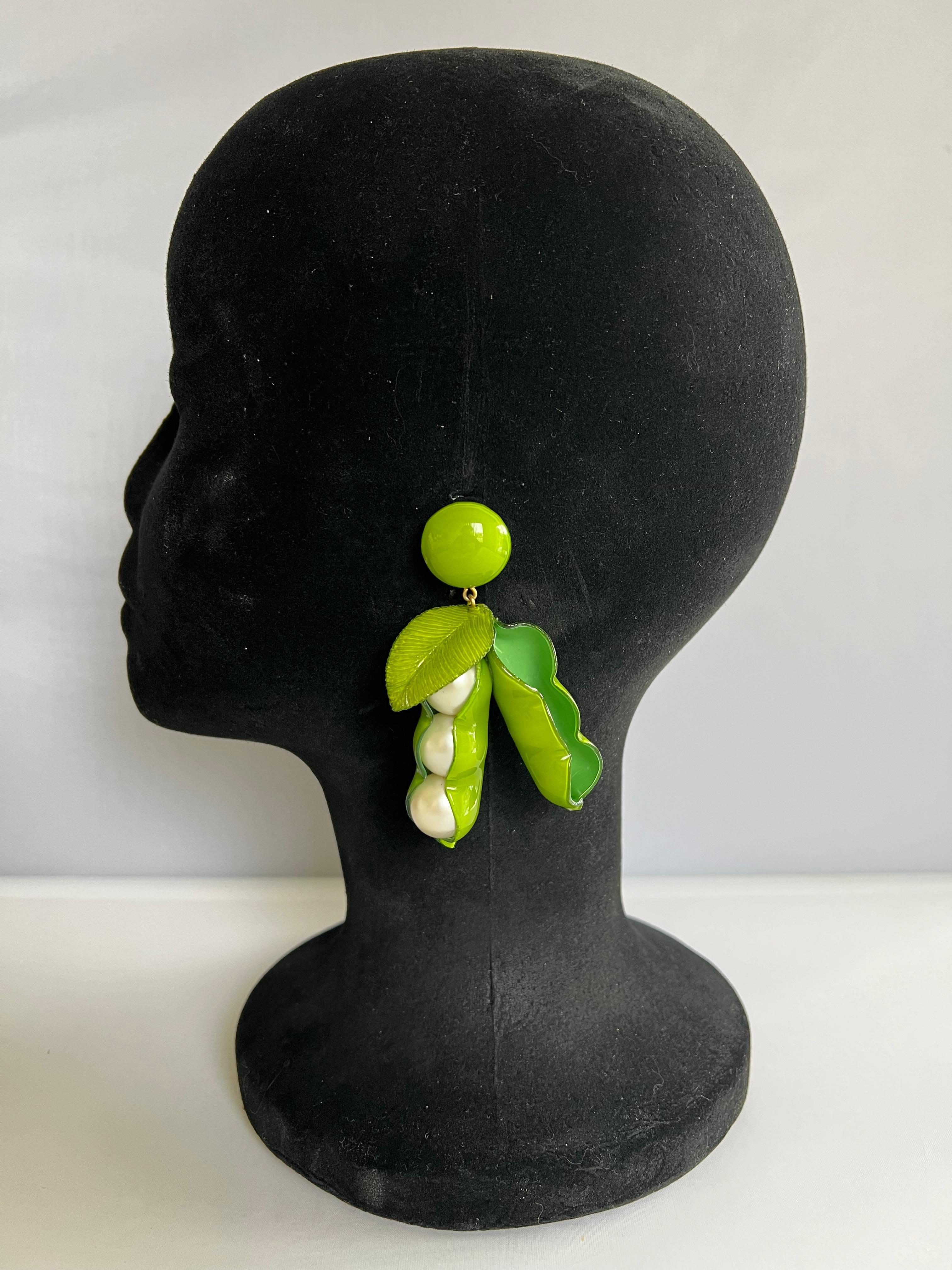 Light and easy to wear, this handmade artisanal pair of earrings was made in Paris by Cilea. The earrings feature two large whimsical peas in a pod of enameline (enamel and resin composite) with faux pearl center details. A unique, well-crafted