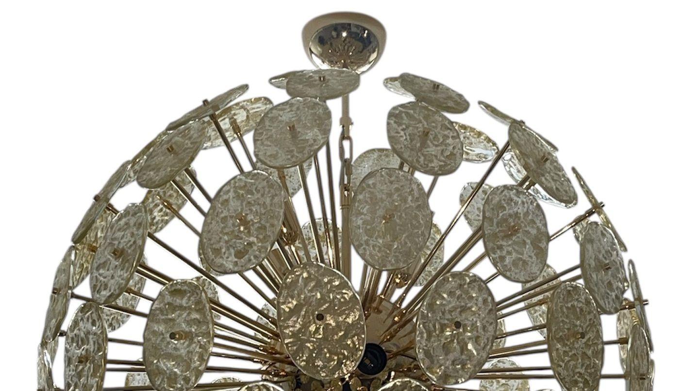 Remarquable lustre Sputnik italien composé de disques ovales en verre de Murano texturé dans une subtile teinte or clair, montés sur une luxueuse monture en métal plaqué or 24 carats. Conçu dans les années 1980, ce lustre surdimensionné incarne