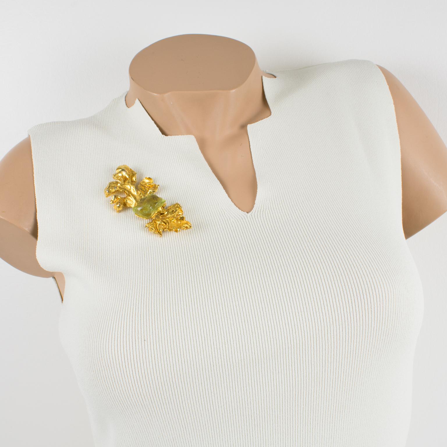 Superbe broche fleurie d'Antigona Paris. Forme dimensionnelle surdimensionnée en métal doré d'inspiration florale surmontée d'une énorme pierre en résine en forme de rocher de couleur vert menthe clair transparent. Fermoir de sécurité. Poinçon