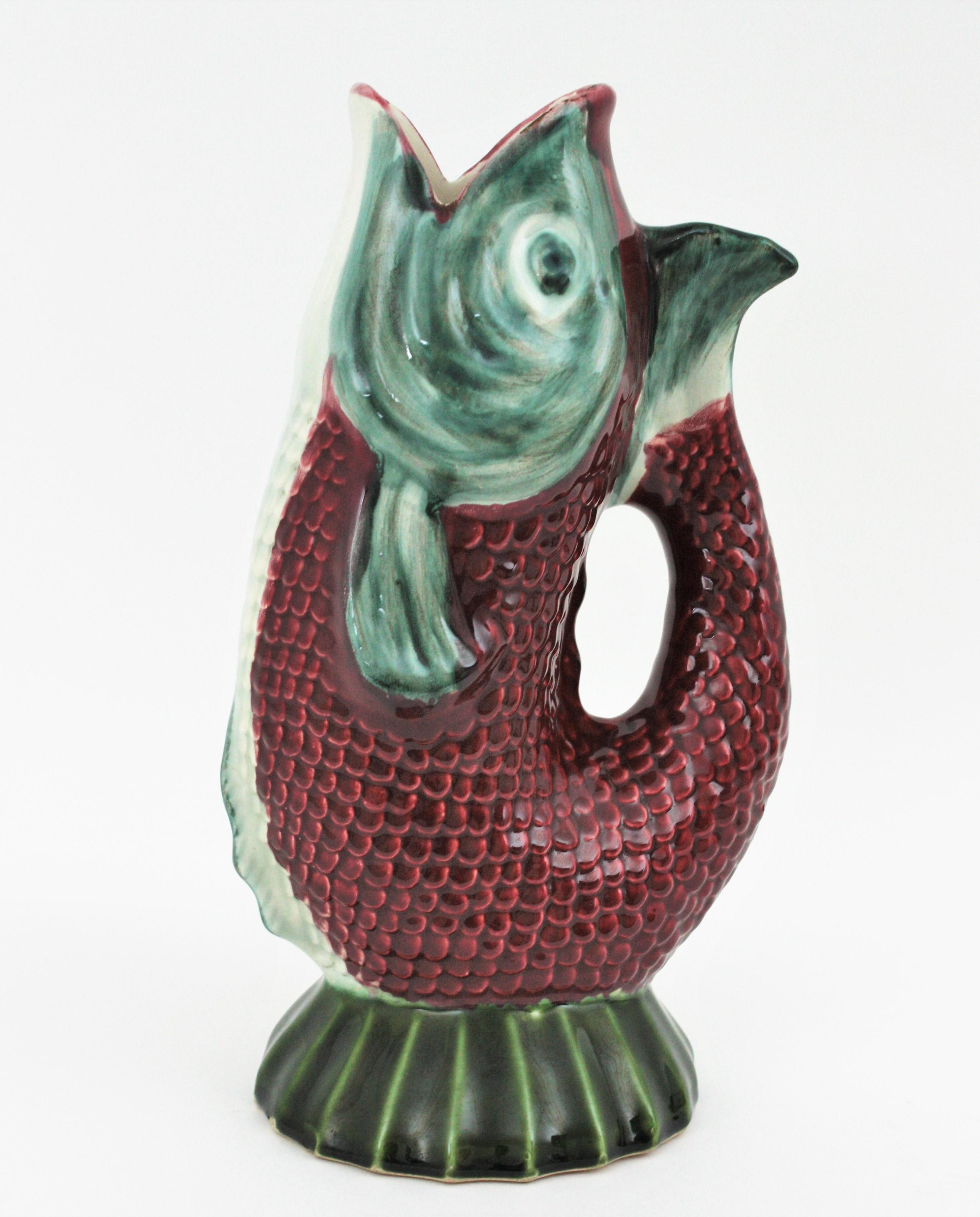 Oversized Mid-Century Modernist glazed ceramic gurgling fish water jug / pitcher. Portugal, 1930s-1940s
Eye-catching hand painted burgundy red, white and green large Majolica ceramic vase, fish glug jug or pitcher.
This fish jug vase will be a