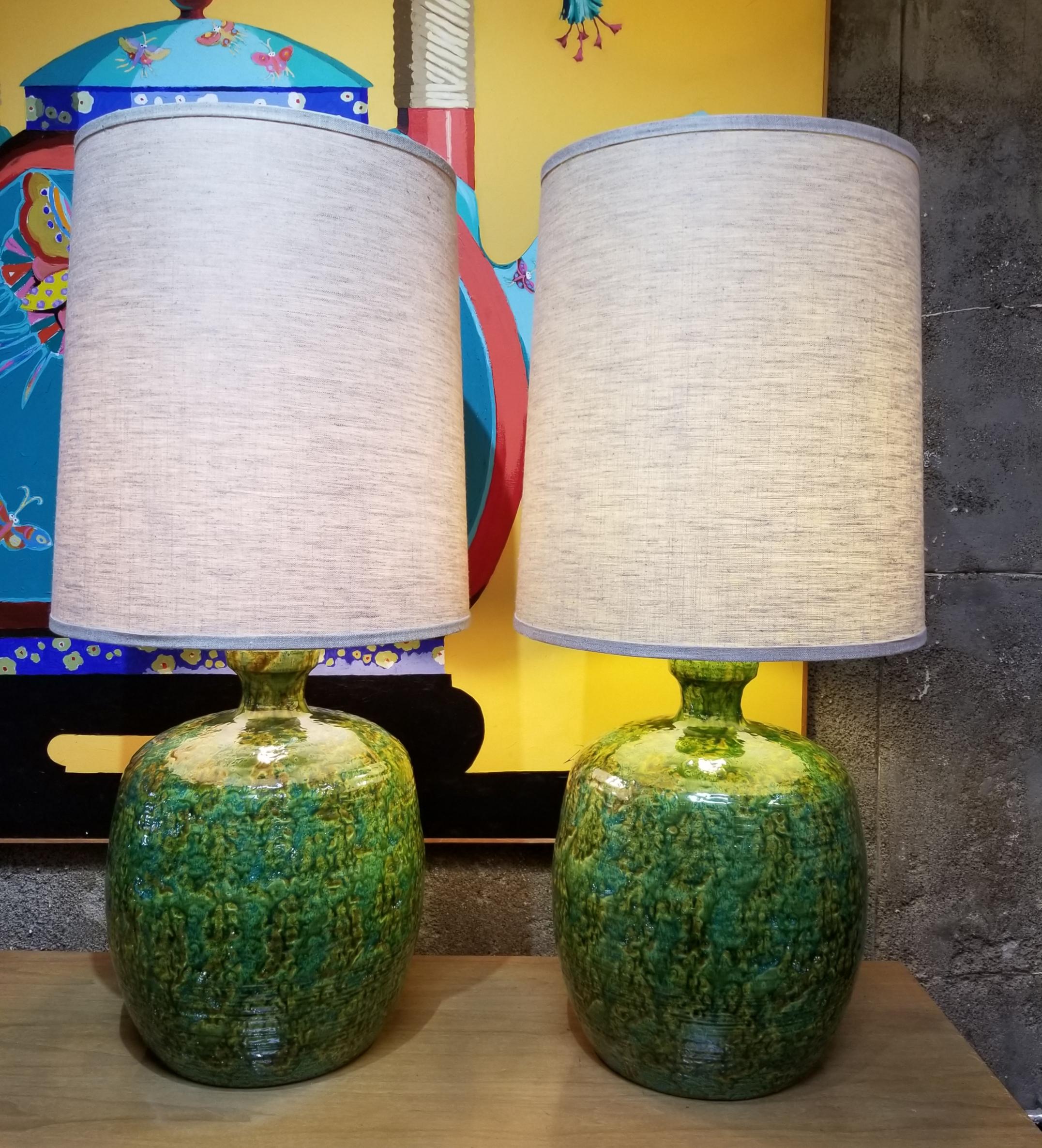 An impressive pair of mottled green, hand-thrown Mid-Century Modern ceramic table lamps with original shades. Amazing original condition. 3-way sockets. Ceramic base only measures 18.5