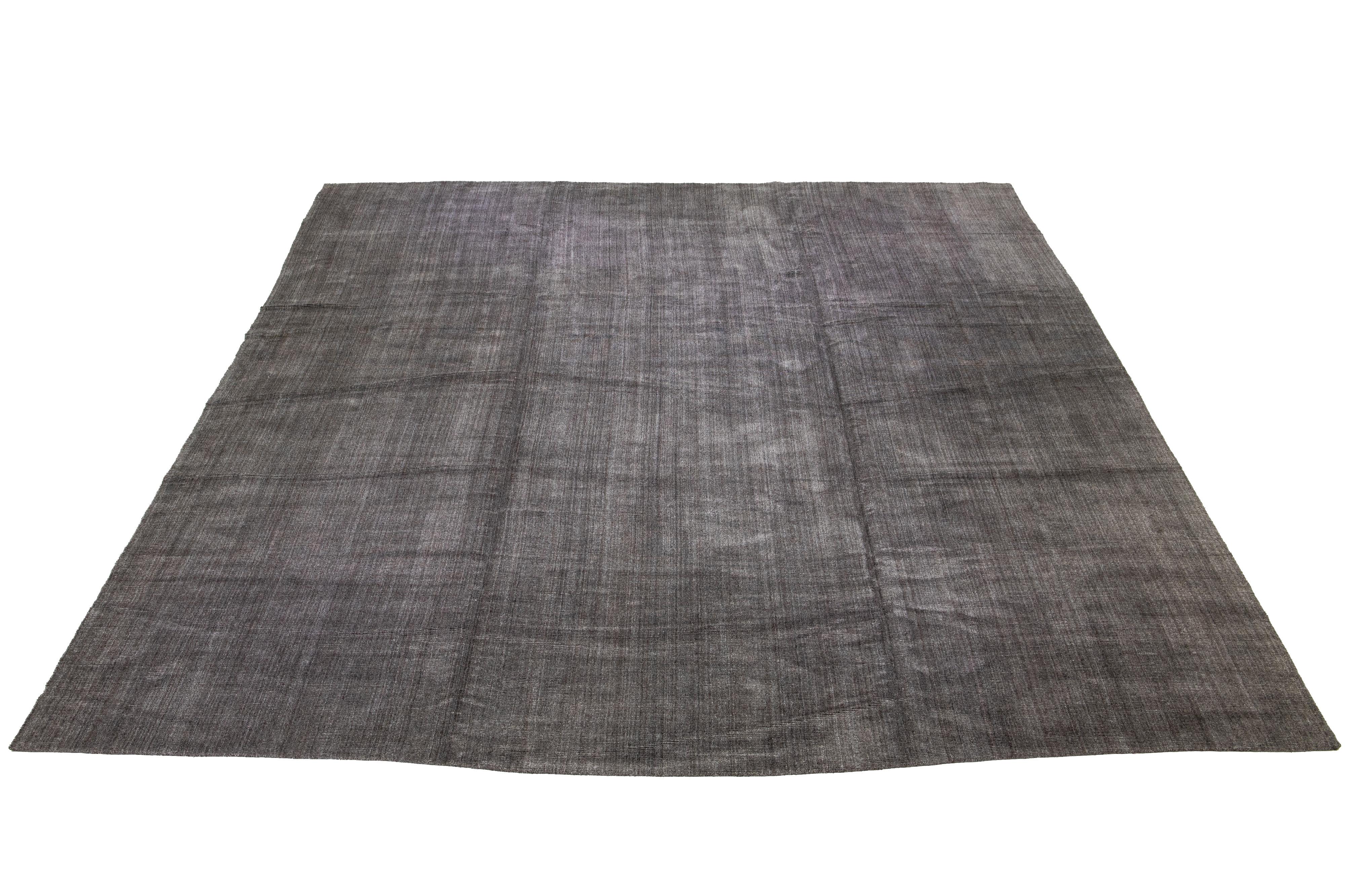 Wunderschöner, übergroßer, handgefertigter Teppich aus Indien mit einer Kombination aus Bambus-, Seiden- und Wollmaterialien und einem herrlichen grauen Feld. Dieser Teppich besticht durch sein unifarbenes All-Over-Muster.

Dieser Teppich misst