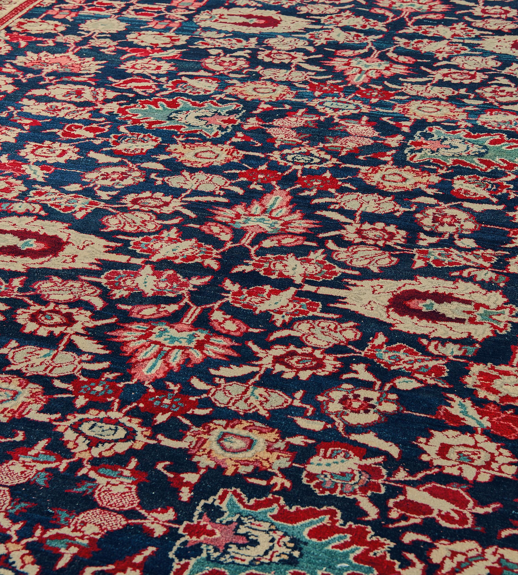 Cette ancienne coulisse d'Agra, datant d'environ 1900, présente un champ bleu indigo avec un ensemble dense de palmettes et de vignes florales rouge riche, jaune sable, bleu clair, rose poussiéreux et vert d'eau, dans une étroite bordure jaune sable