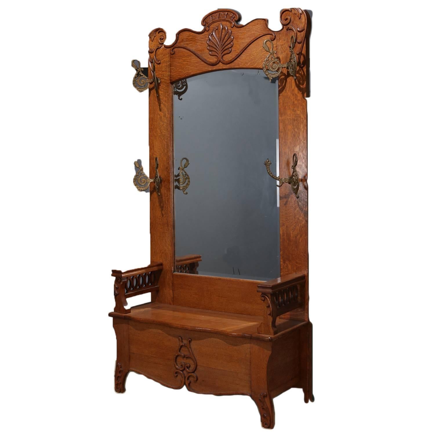 Oversized Horner School hall tree features oak construction with crest having carved central shell and flanking scroll and foliate decoration, pierced arms flanking the scalloped lift top seat, circa 1910

Measures: 90.5