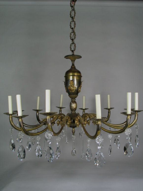 A large bronze two-tone chandelier draped with crystal.
  