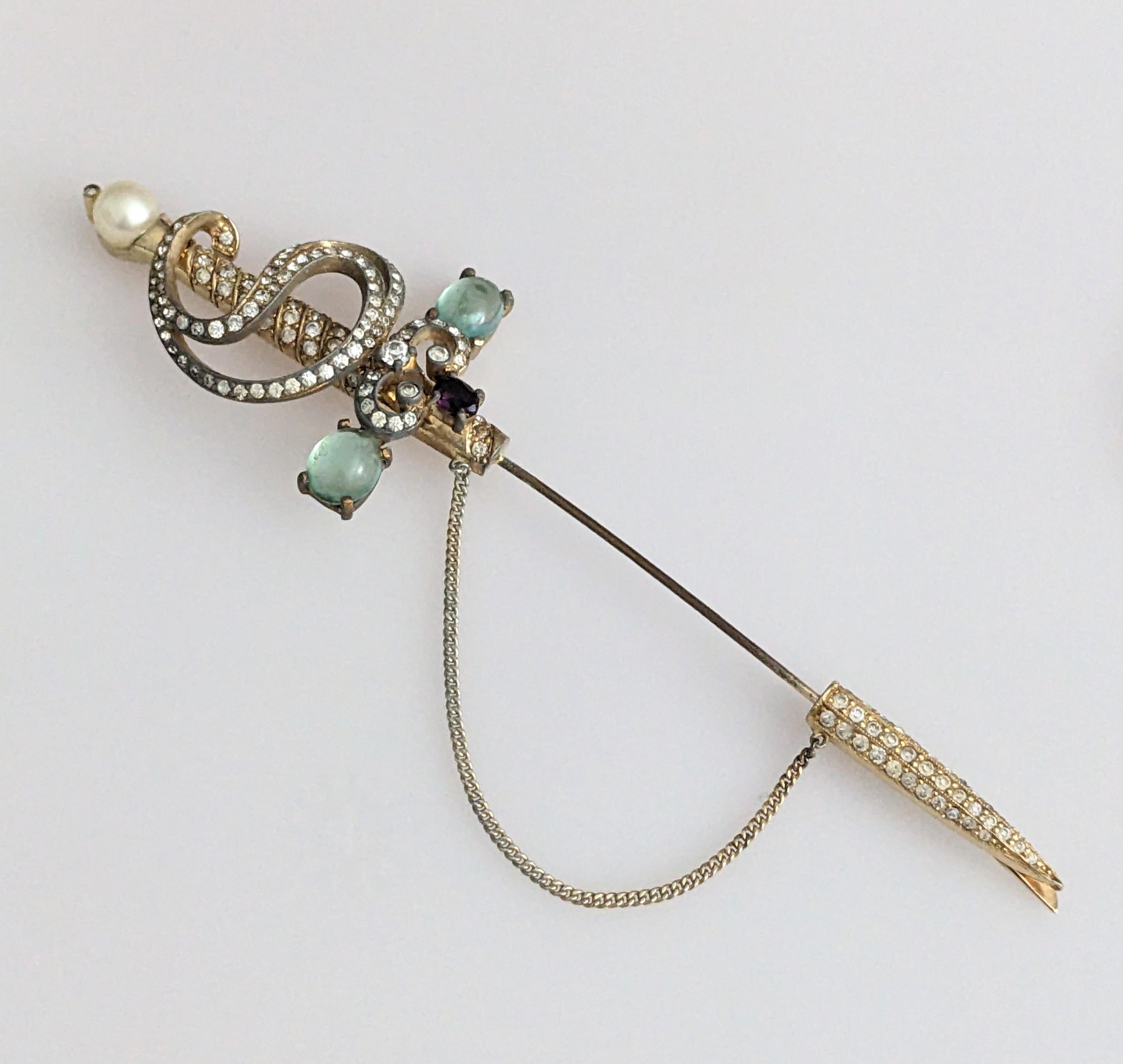 Large Jomaz jabot pin set with pastes, pearls with faux amythest and emeralds from the 1950s. Large sword motif on gilt metal, great on coat or jacket. Excellent condition, 5.75
