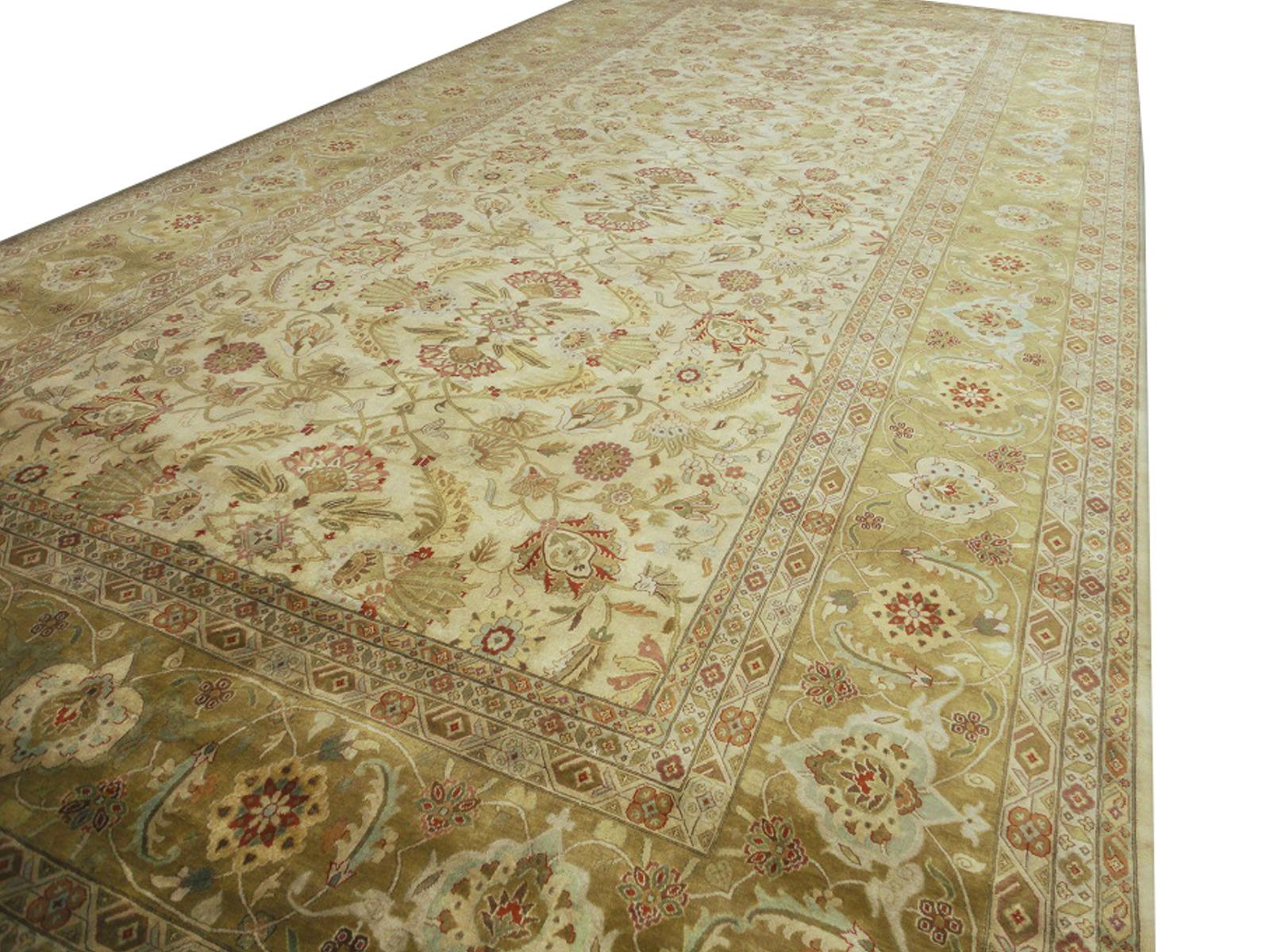 A beautiful oversized contemporary design carpet, hand knotted using finest wool. On a light crème field, the design of Lotus blossoms standing next to each other executed in gold, red and green tones. Design Influences are from Persian Tabriz