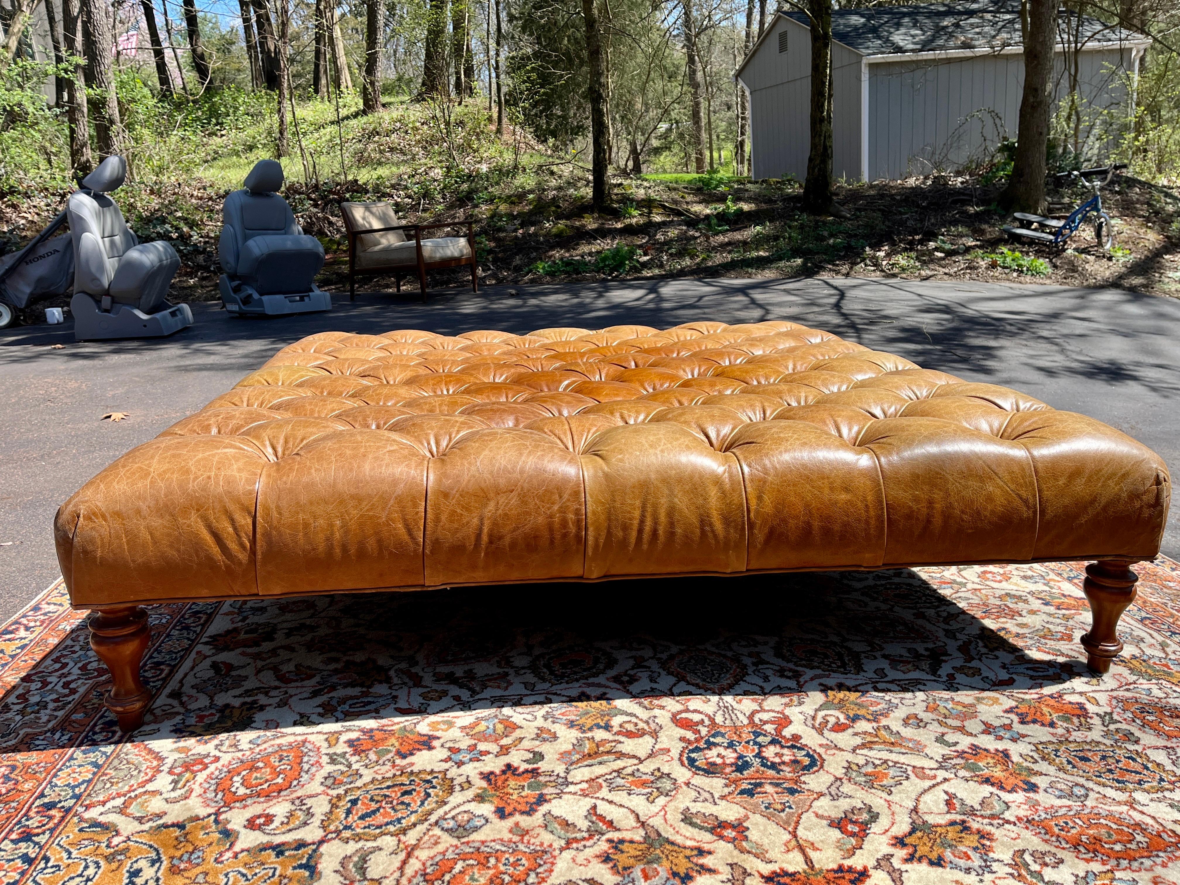 A beautifully patinated leather button tufted ottoman.