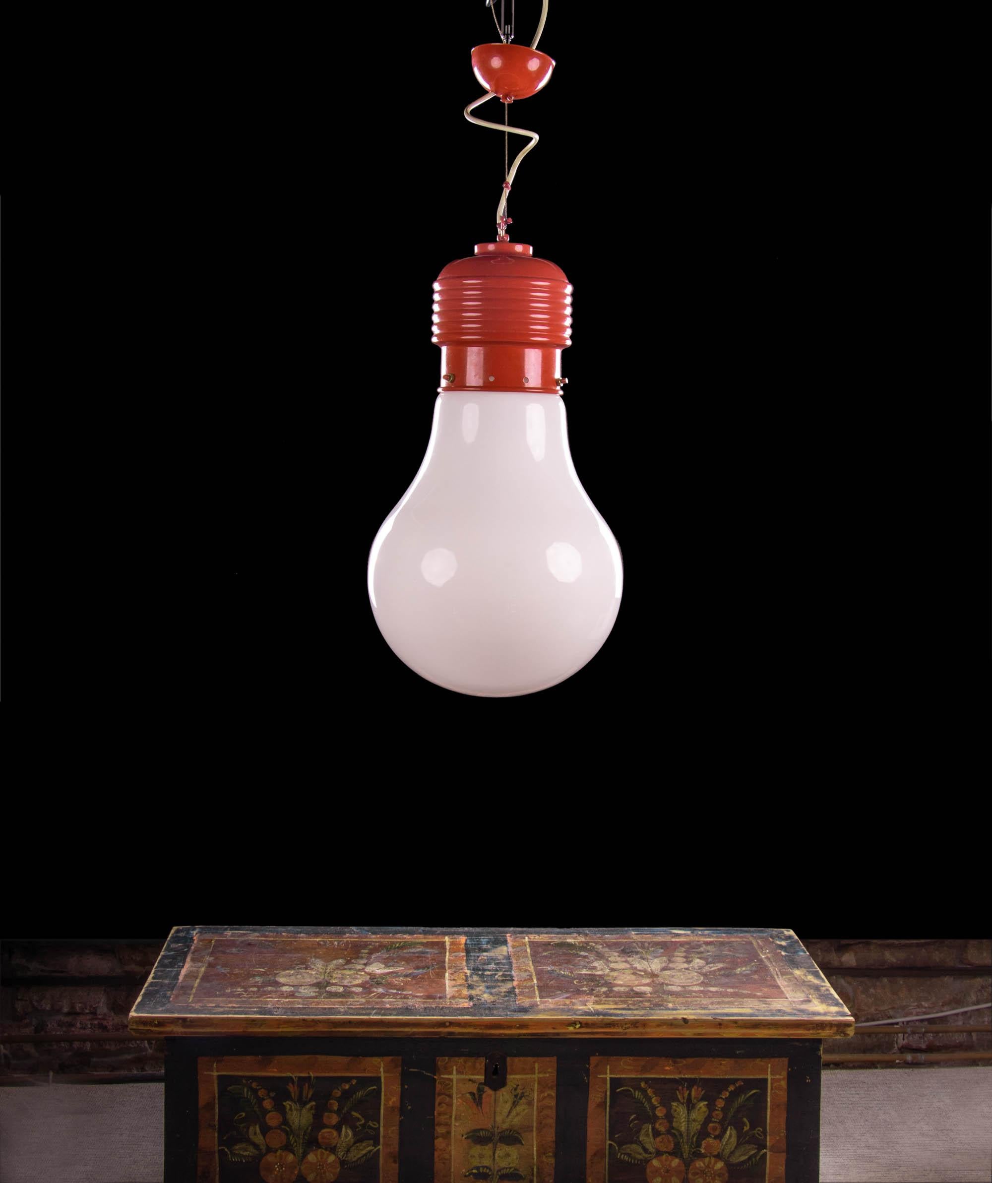 Vintage oversized lightbulb ceiling light designed in the manner of Ingo Maurer. Manufactured in Germany, 1960s-1970s. 

Materials: glass and brass. 
Colors: red and white. 
Measures: diameter 11.8