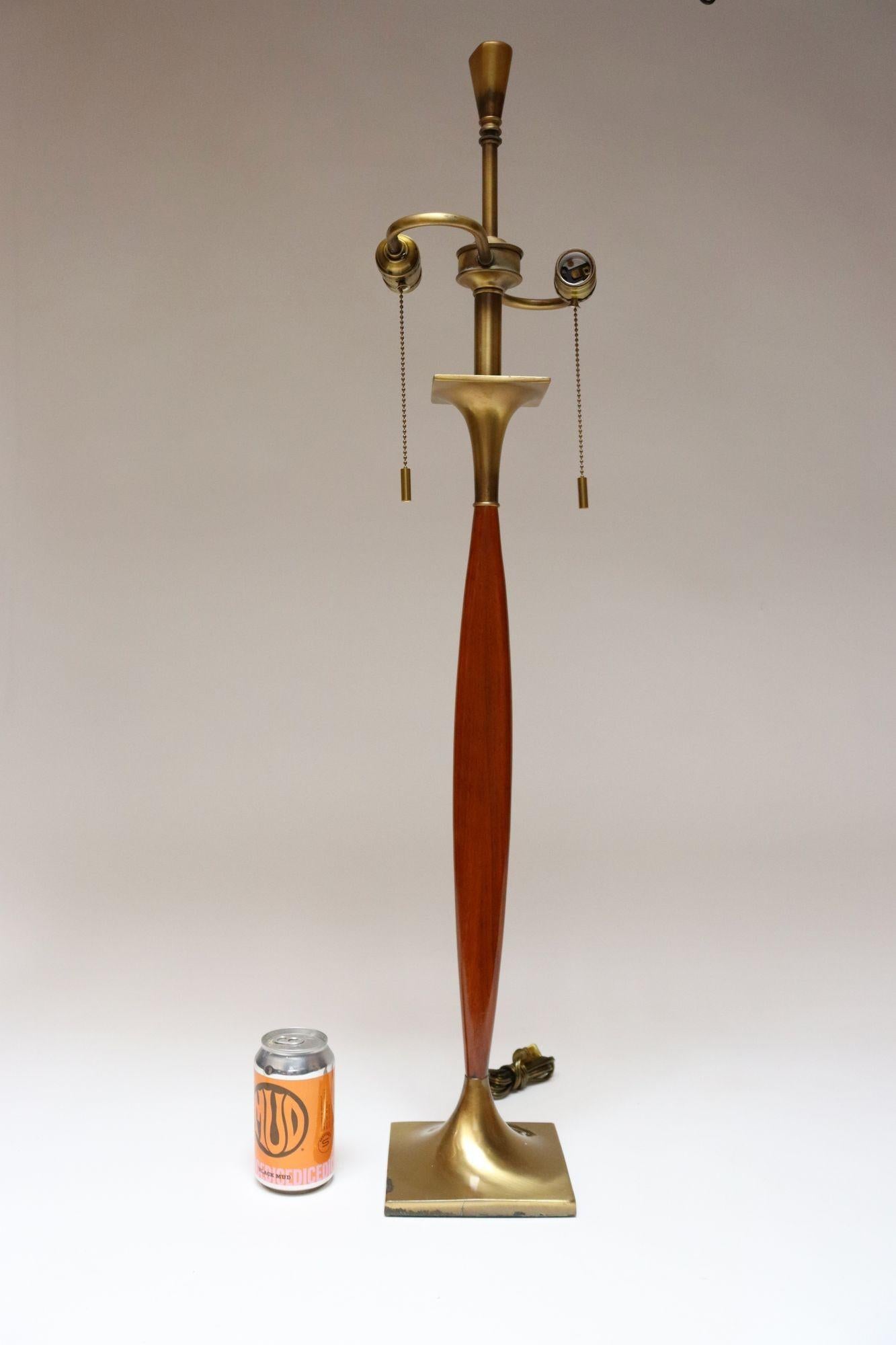 Lampada da tavolo Laurel statuaria composta da uno stelo ellittico allungato e sottile in noce con base rettangolare e accenti in ottone lucido (ca. 1960, USA).
Il cablaggio è stato rifatto di recente con interruttori e prese di corrente a doppio
