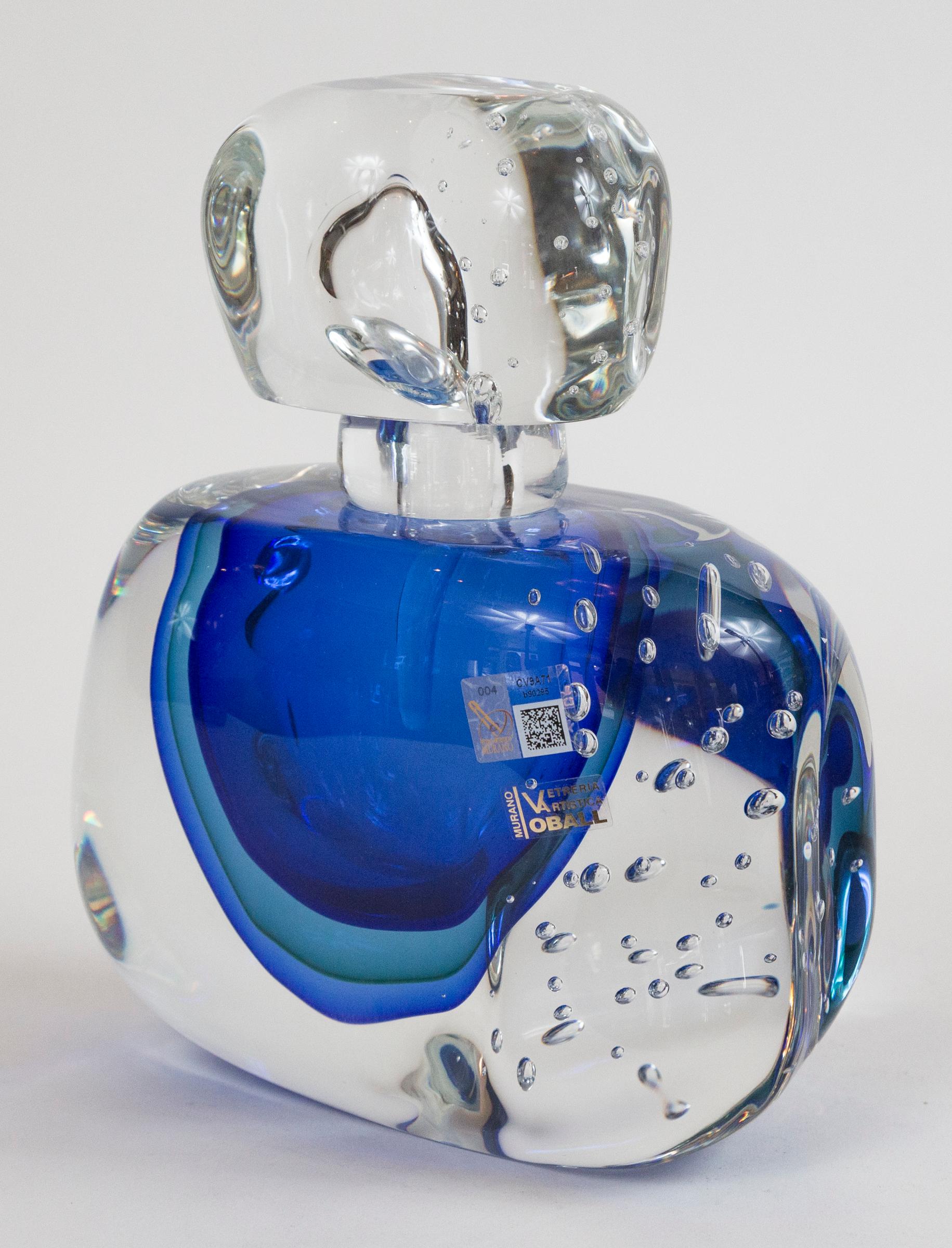 Wonderful one of a kind artisan blown irregular block-shaped bottle and dramatic stopper shown with large controlled bubbles and center floating orb shape in four layers of blue color-  executed in the sommerso technique, signed by the artist,
