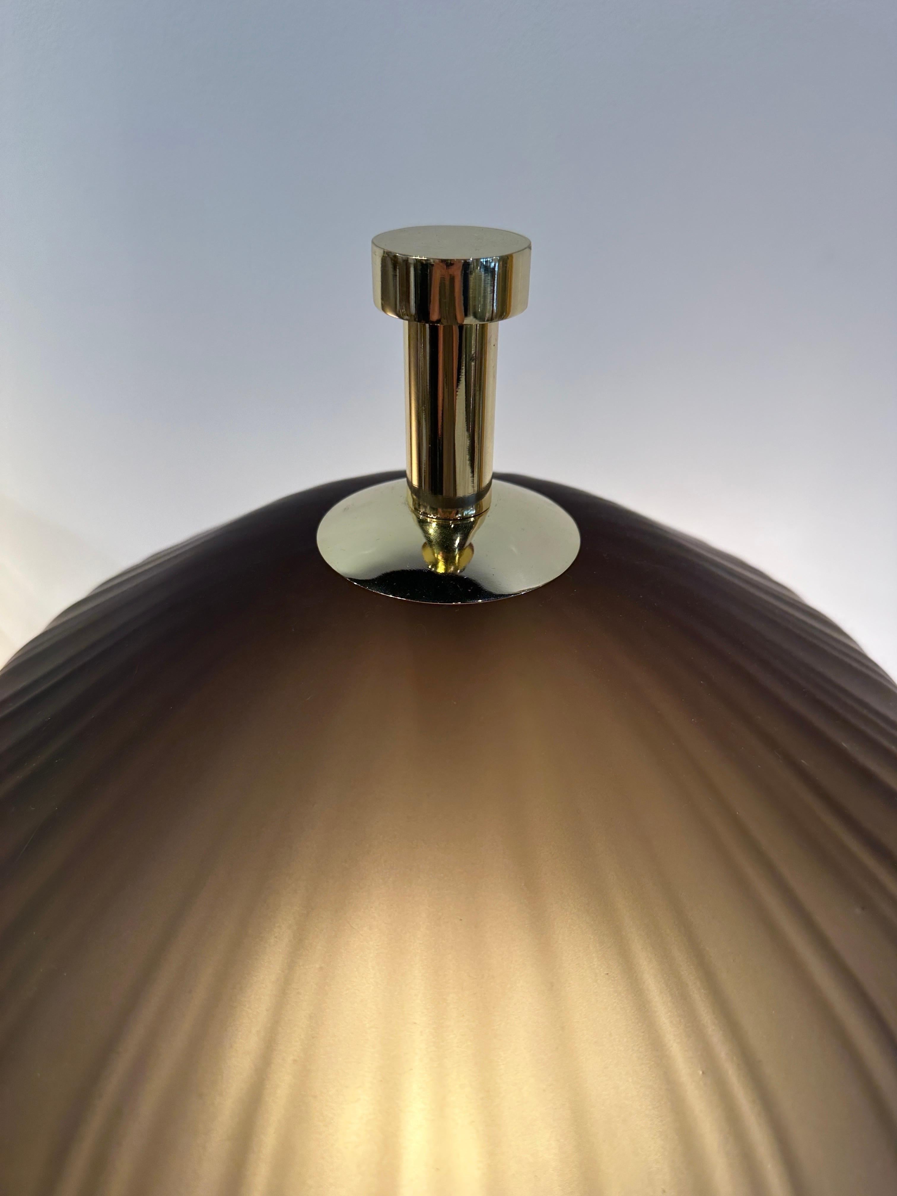 In the Japanese style these large Murano glass shades sit atop a brass base to create a whimsical modern take on a Japanese floating lantern design. The glass has a light brown hue when not illuminated and more of a caramel hue when illuminated -