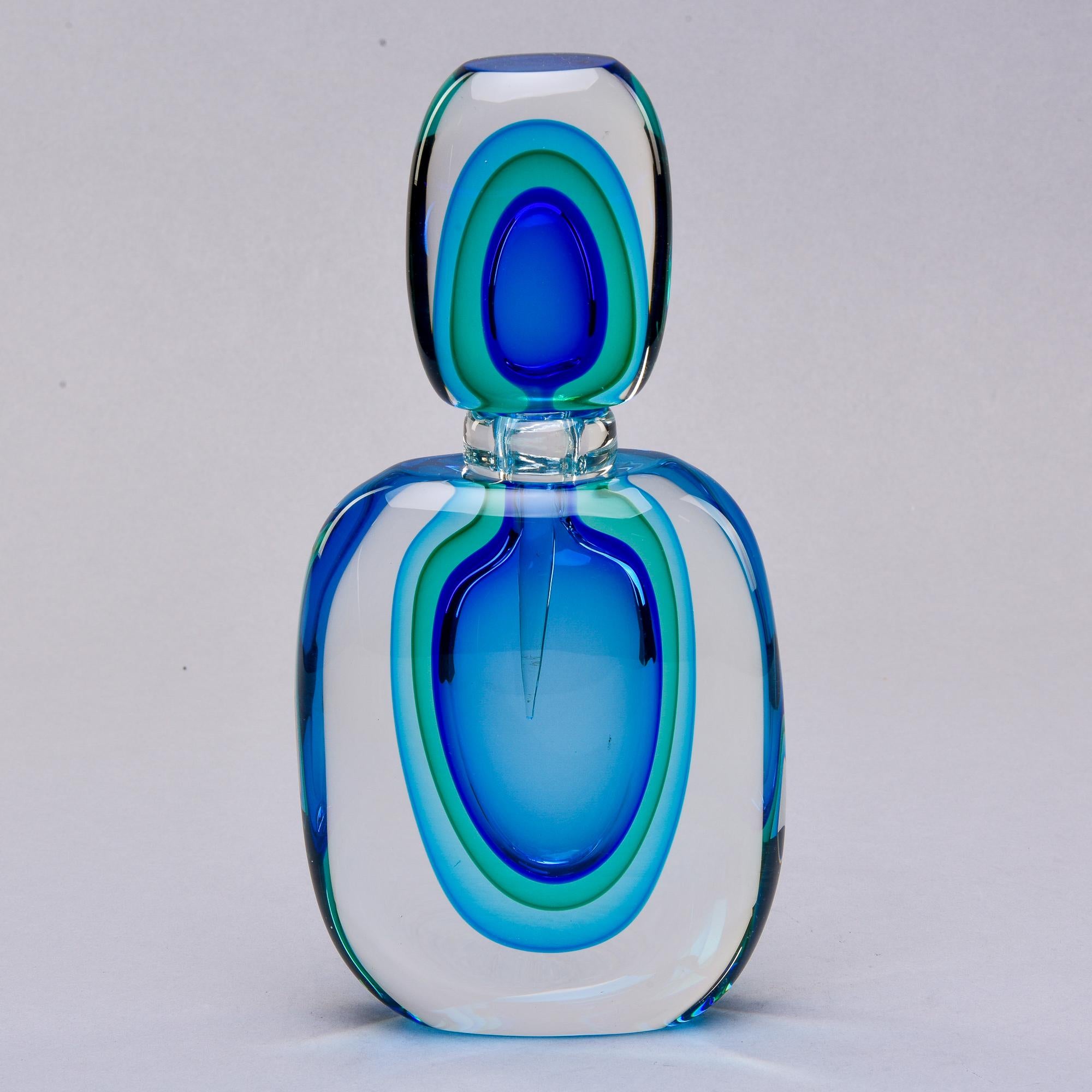 New Murano perfume bottle made of heavy, clear cased glass with suspended layers of sommerso-style glass in shades of blue and green. Top has attached perfume dabber. We have three bottles in this style and color way in varying sizes. See last photo