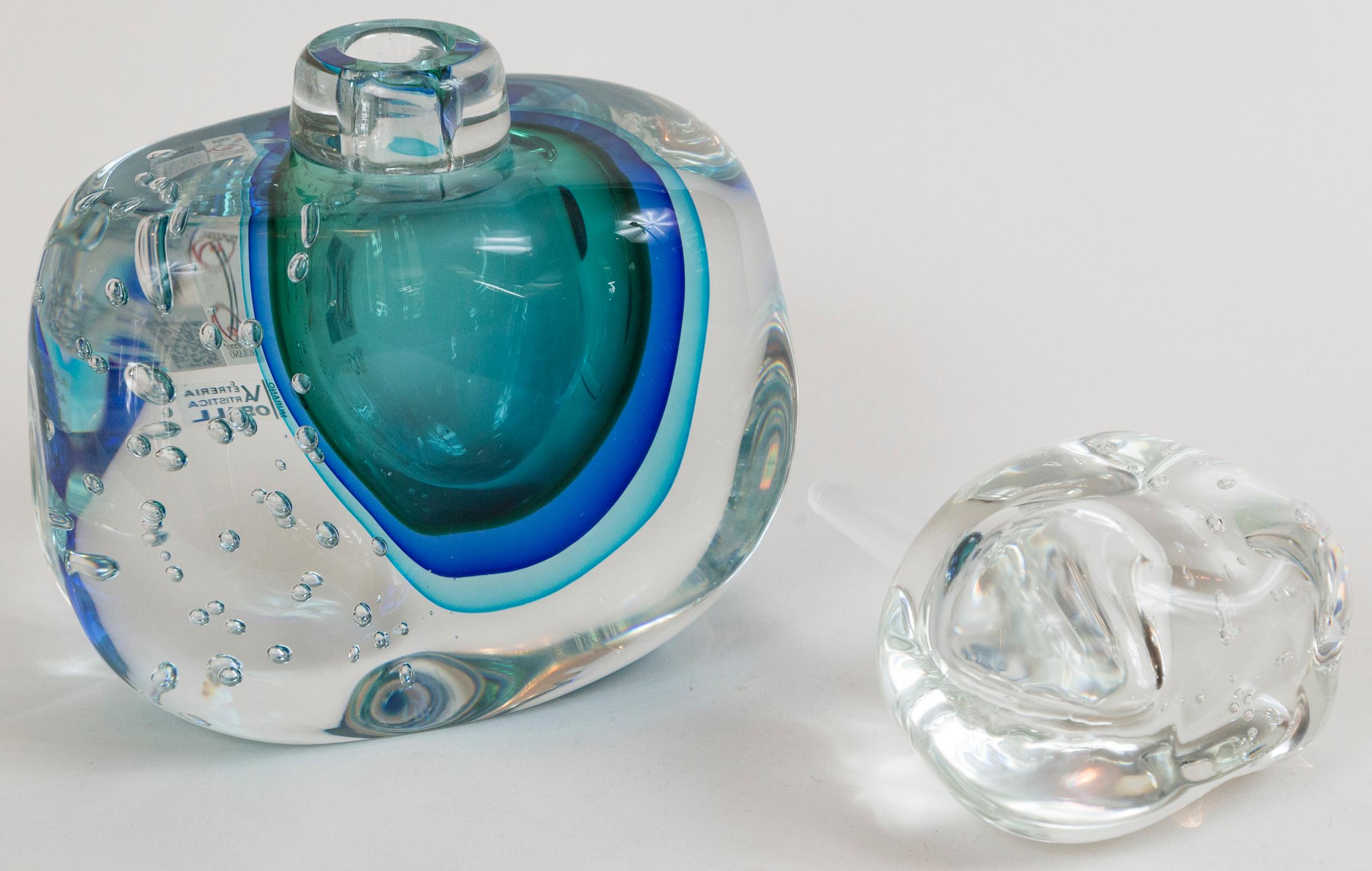 Wonderful one of a kind artisan blown irregular block-shaped bottle and dramatic stopper shown with large controlled bubbles and center floating orb shape in three layers of blue color- executed in the sommerso technique, signed by the artist,