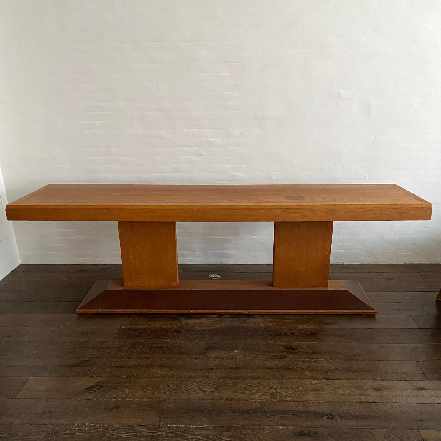This beautiful and architectural antique console was sourced and and made in France and estimated to be from the 1940's. The oversized piece is made from natural French oak with an appropriately aged patina and a very handsome leather detailed base.