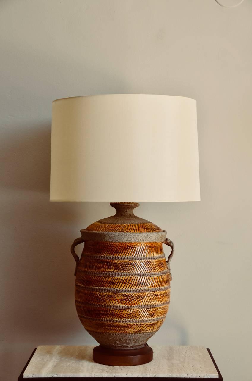 Oversized ochre glazed ceramic urn lamp. Interesting combination of striated glazed and unglazed surface. Custom silk shade with top diffuser.

 