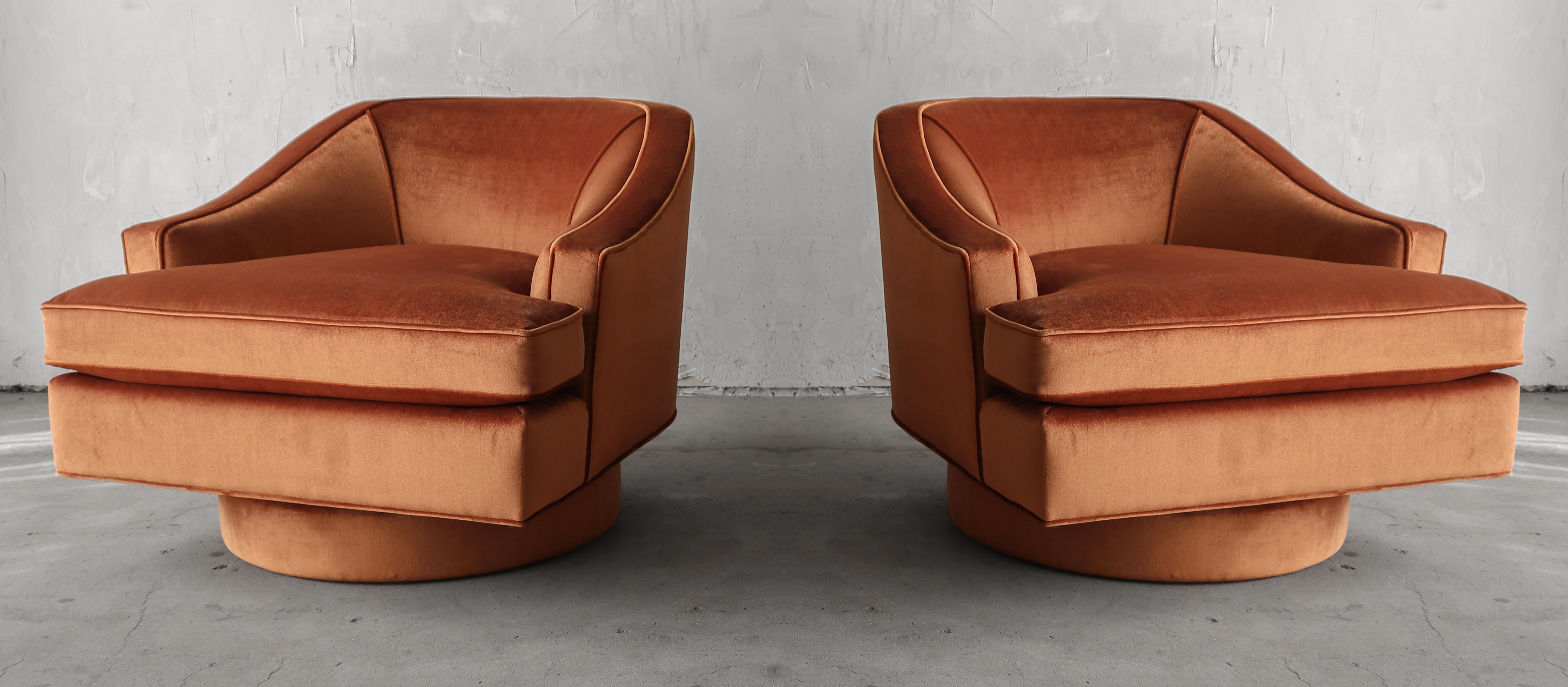 This is a beautiful pair of midcentury barrel back swivel chairs with large plinth bases. This pair has beautiful lines that can be appreciated from almost any angle. 

The chairs have been professionally restored, they are installation ready.