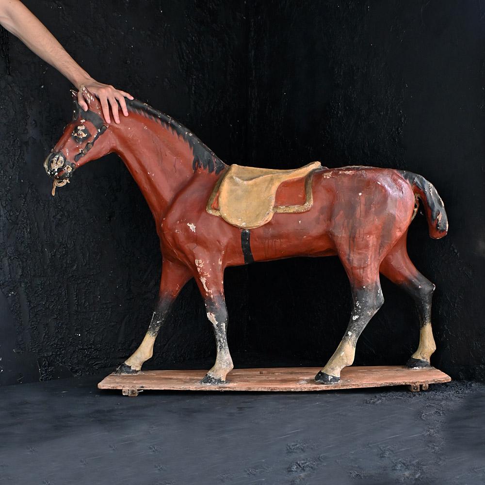 Oversized Papier Mache Childs Pull Along Toy Horse 
A larger than the normal example of an early 20th century papier Mache child’s pull along toy horse. Stood on its original pine base, this example stands 38 inches tall. With aged wear and tear due
