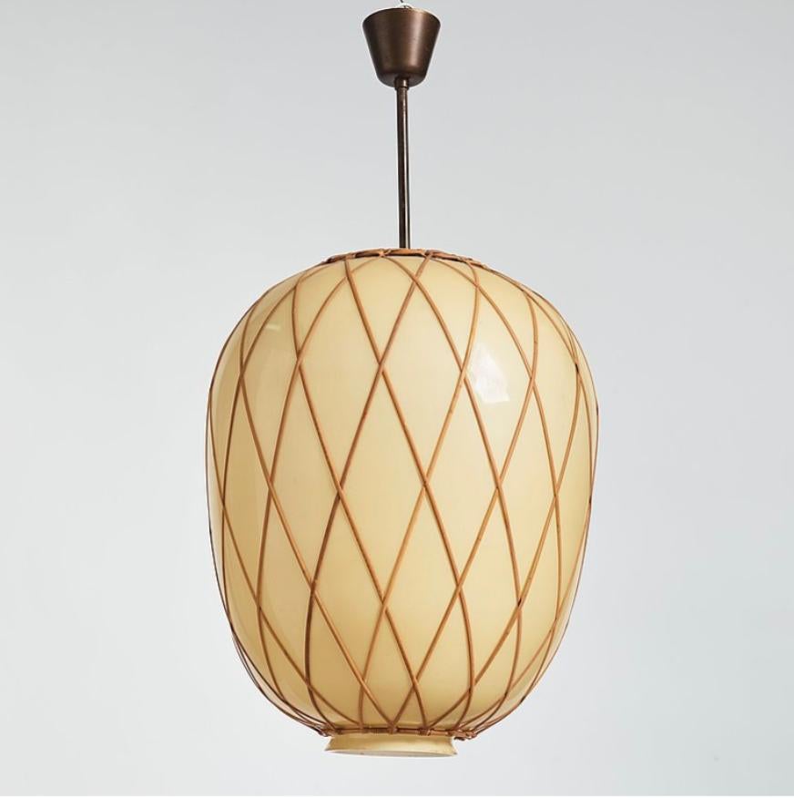 Oversized pendant designed by Harald Notini for Bohlmarks, Sweden, circa 1940th.
Handblown glass shade with vanilla exterior and opaline interior, with cane decoration and brass hardware. Single, Edison style socket. The glass shade dimension H