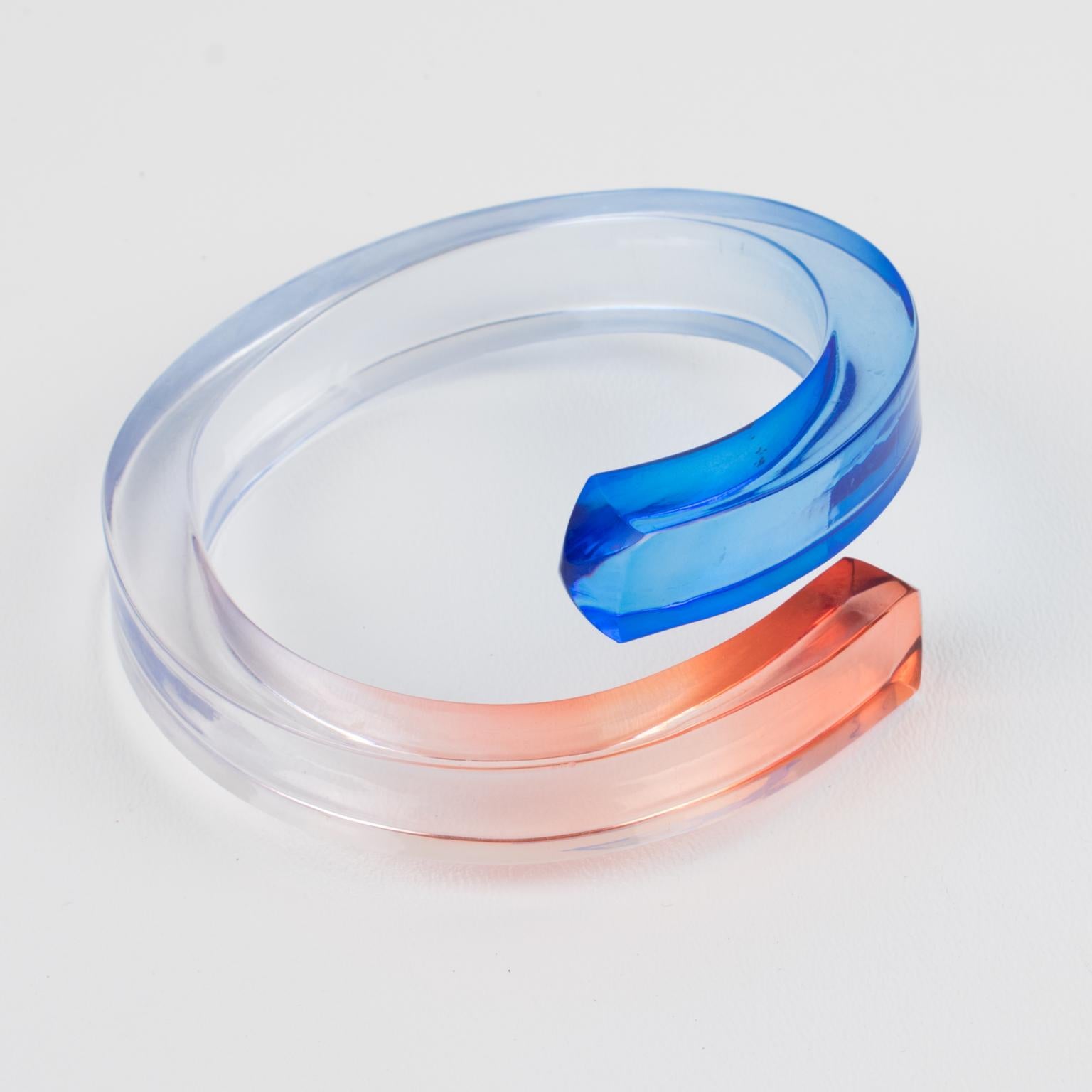 This stunning 1980s Space Age sculptural Lucite bracelet bangle features a chunky hand-crafted oversized coiled, wrapped shape with mostly transparent color and endings in arctic blue and salmon pink colors. There is no visible maker's mark.
Good