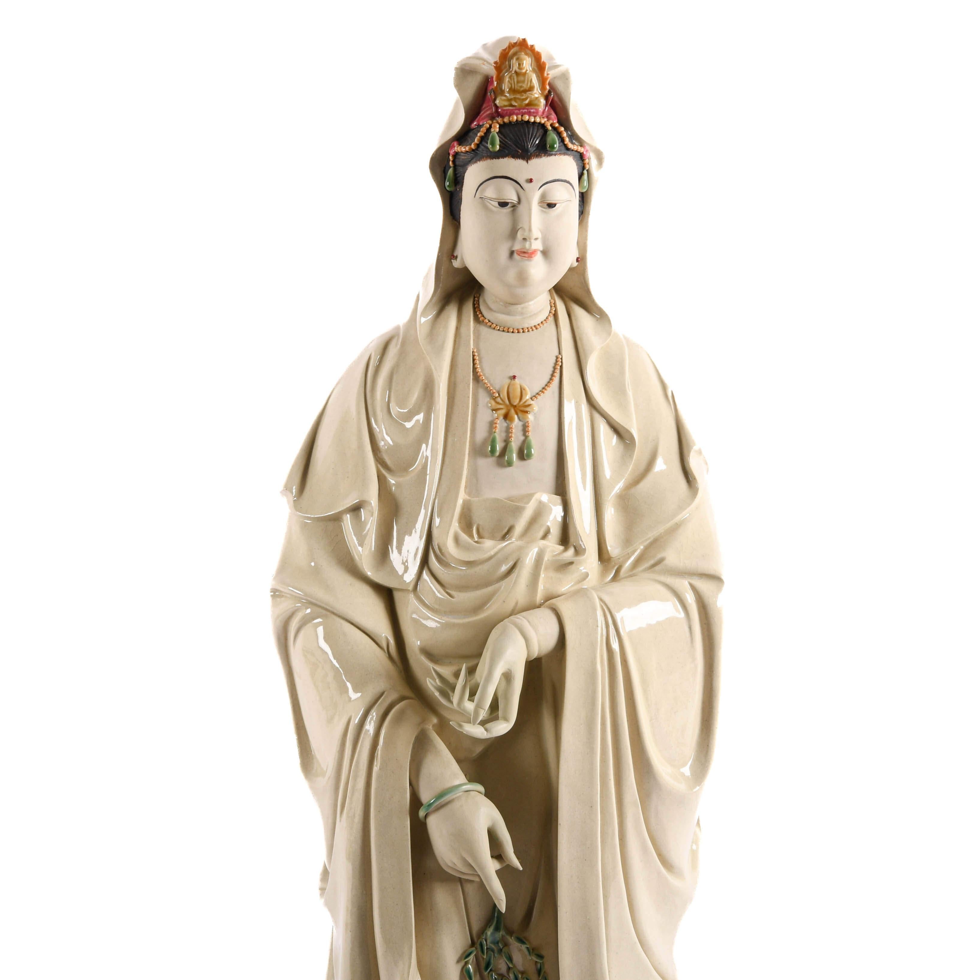 Cette statue chinoise Guan Yin en porcelaine surdimensionnée est une magnifique représentation en céramique de la bodhisattva Revere, connue pour sa compassion et sa miséricorde. Cette figure élégamment sculptée est parée de robes fluides, de bijoux
