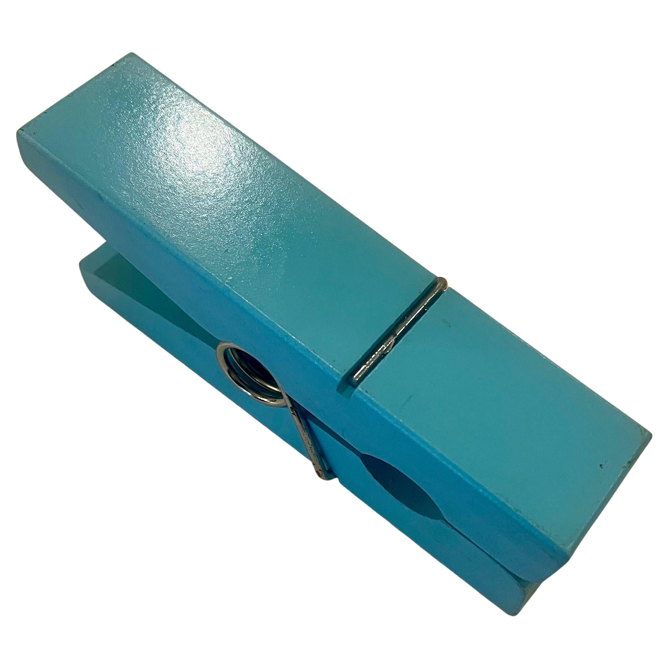 Cool oversized clothes pin in yellow lacqured wood , great to clip notes envelopes in blue finish shows light rust on the chrome spring as shown has a hole to hang it in the wall.
