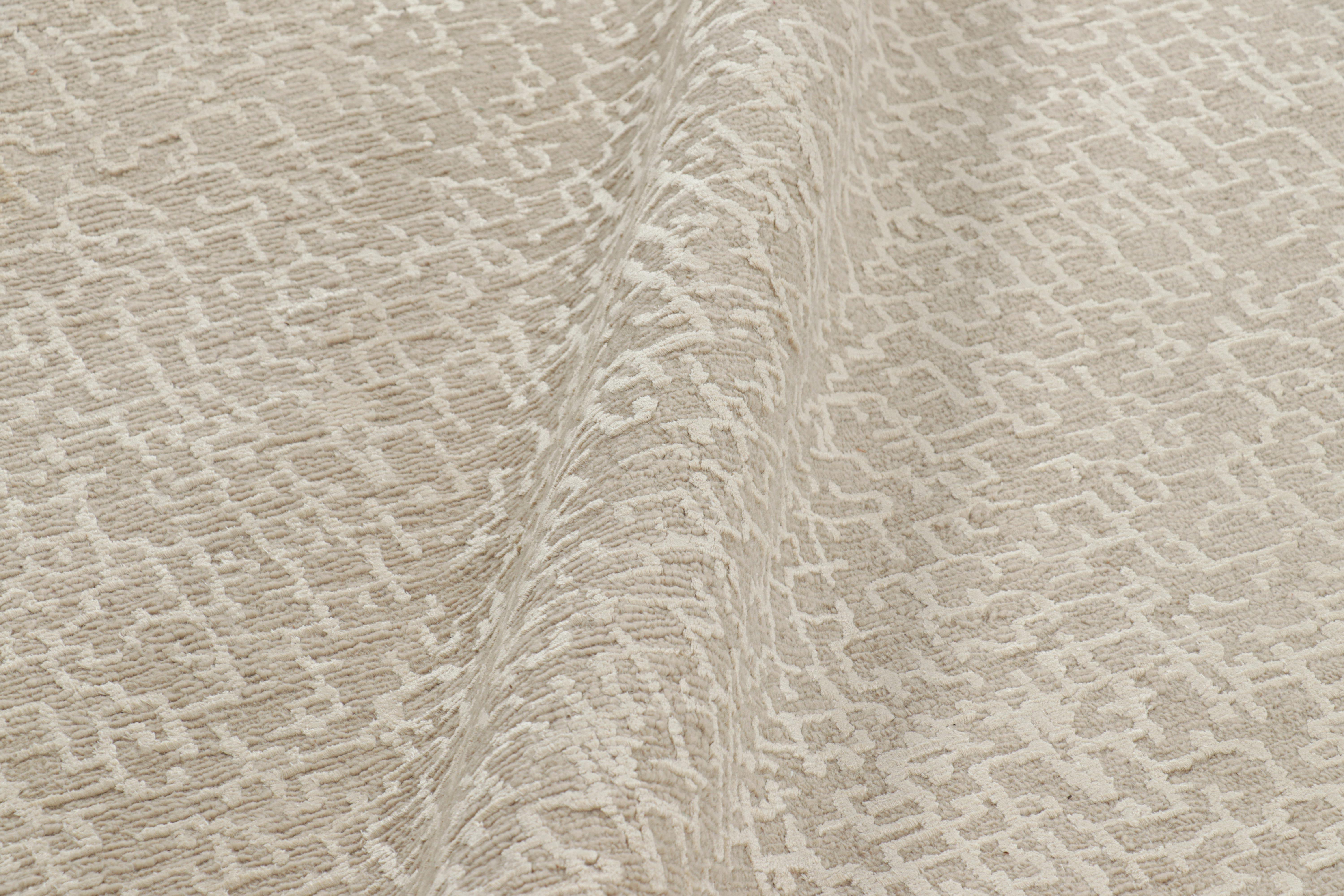 Hand-knotted in wool and silk, this 13x21 smart work both contemporary and textural from Nepal, features variations in color and a boucle-like texture which lend a fabulous sense of dimension to the geometric patterns in creamy tones. 

On the