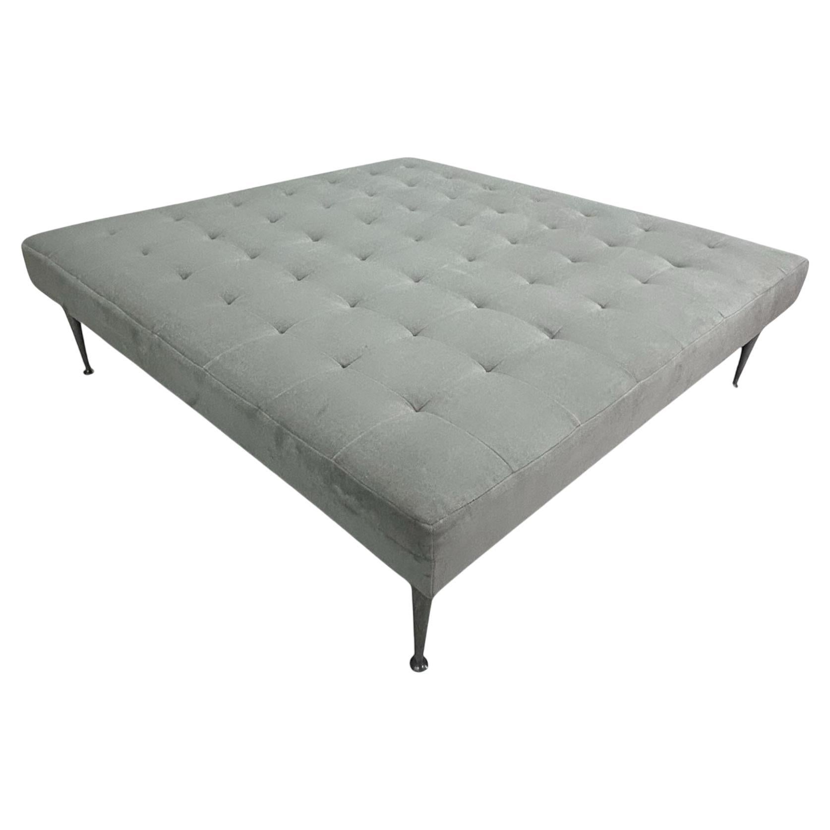 Questo pouf quadrato oversize in velluto grigio chiaro con gambe in ghisa massiccia è un pezzo magnifico.  è rivestito in velluto grigio chiaro di alta qualità con un design a ciuffi fitti, per offrire un look sofisticato e allo stesso tempo una
