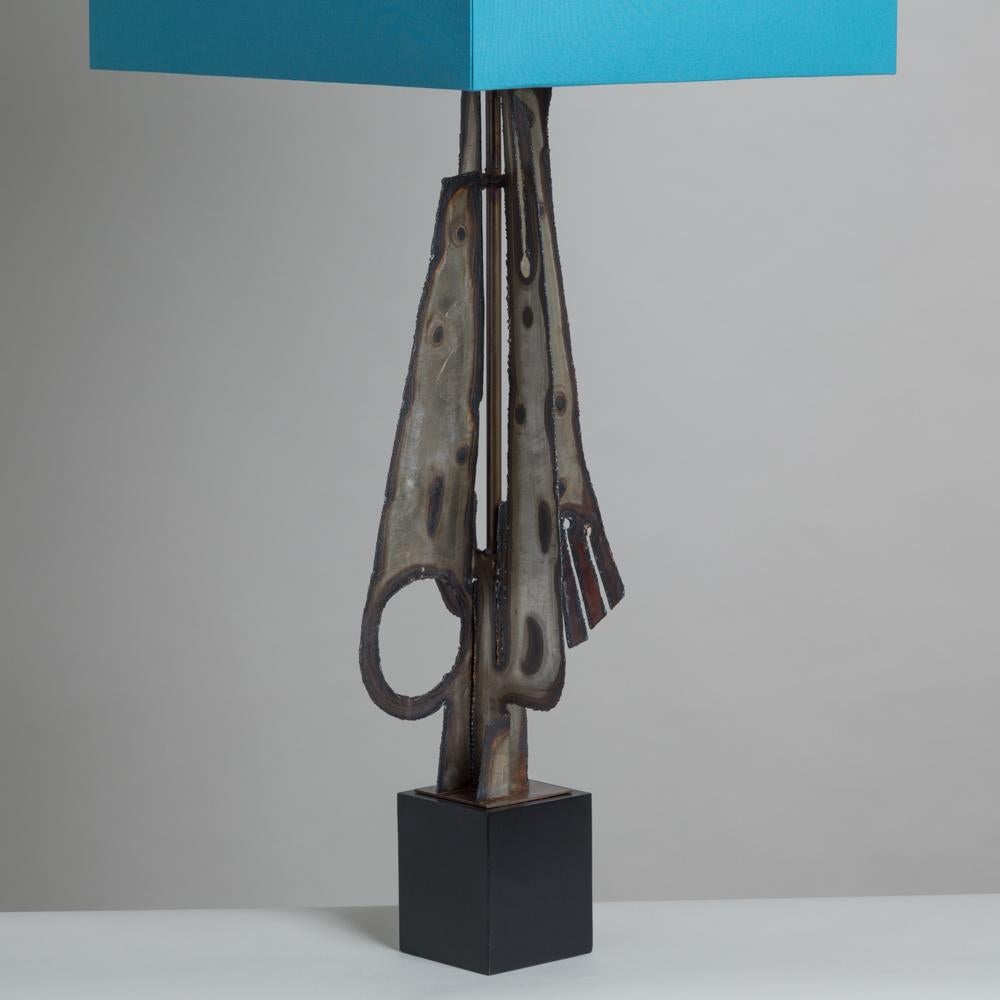 Oversized torch cut brutalist sculptural metal table lamp with a great patination designed by Laurel Lamp Manufacturing Company of Newark, NJ, USA, 1960s with pressed glass detail and on an ebonised base. 
Fully rewired by Talisman and custom made