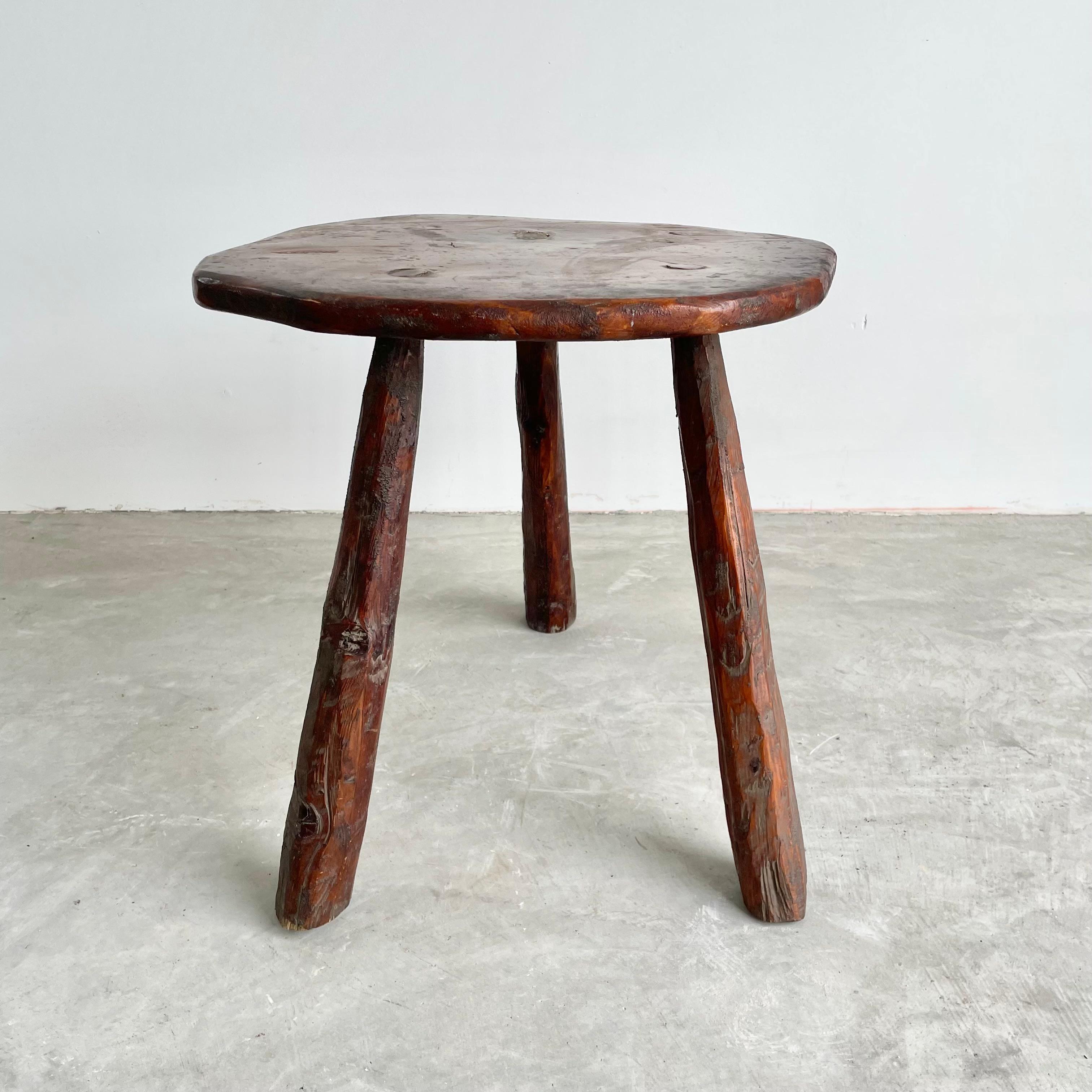 Oversized, chunky wood stool made in France, circa 1960s. Large raw edge seat with three thick club legs. Substantial stool with great lines and posture. Darkened patina and grain to the wood. Perfect for books or objects.
 
