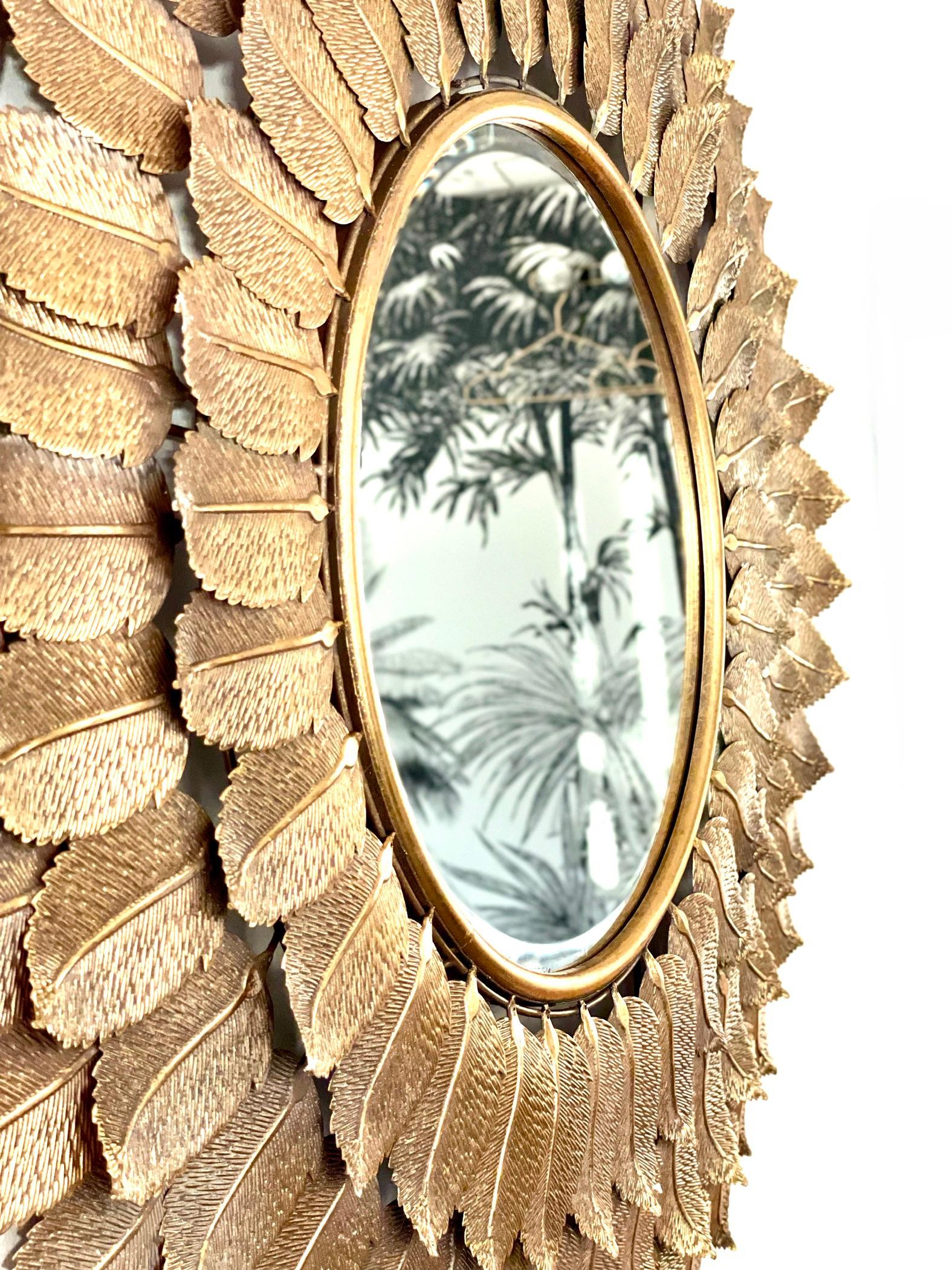 Un impressionnant miroir à feuilles de métal doré en forme de soleil.  En bon état.
