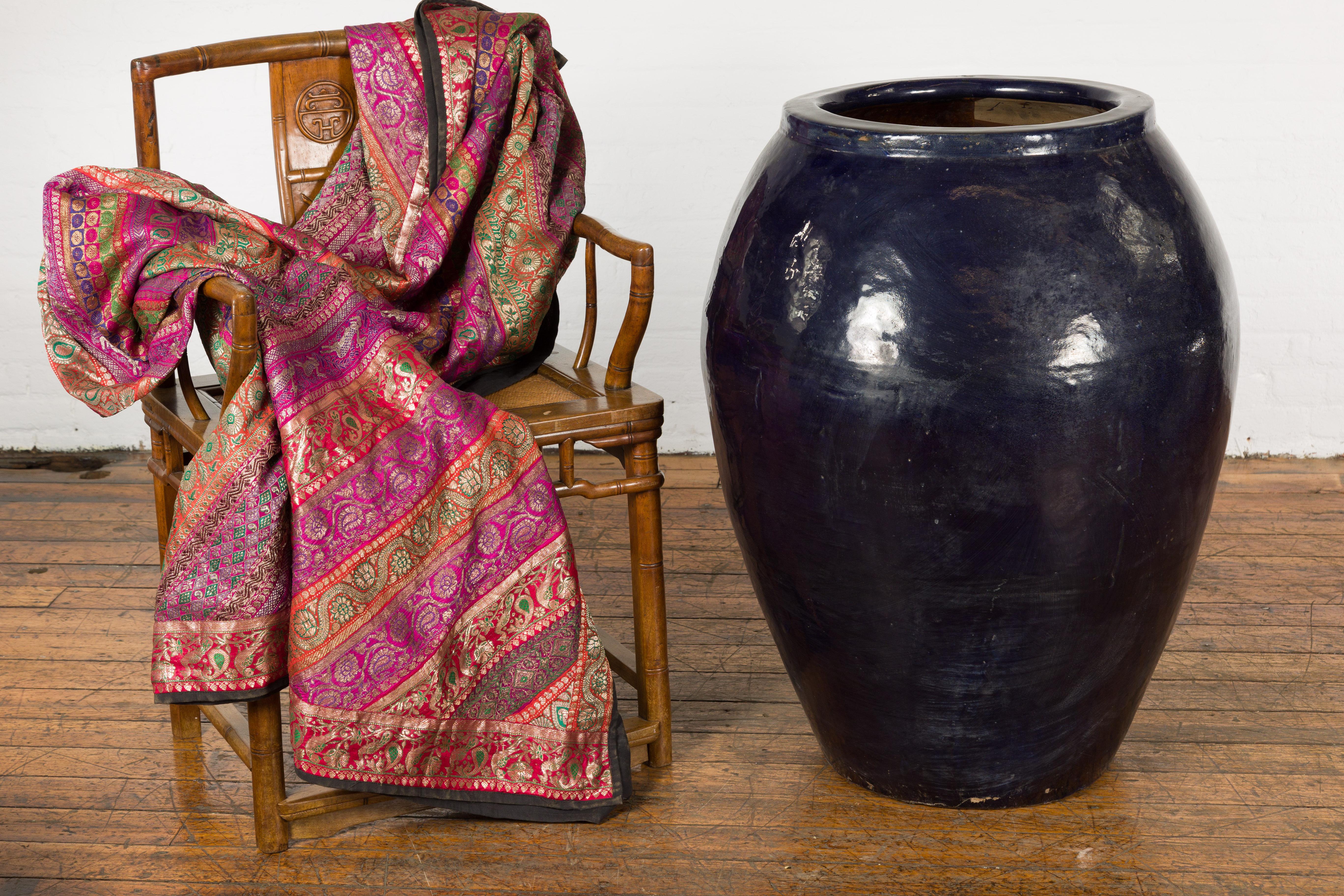 An oversized vintage Thai water vessel from the mid-20th century, with midnight blue glaze, and tapering lines. Created in Thailand during the mid-century period, this oversized water vessel features a circular opening measuring 17.5 inches of