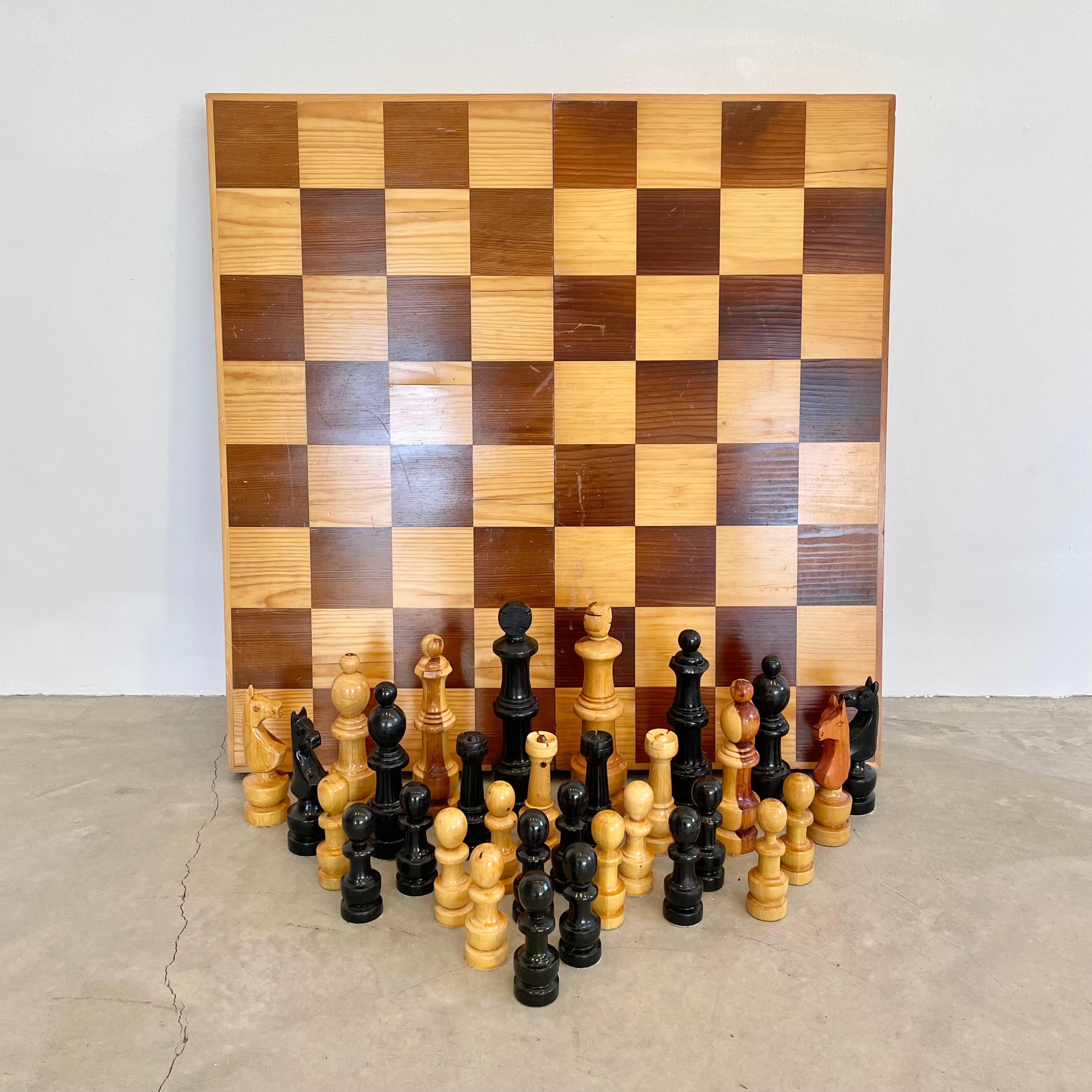 Large oversized folding wooden chess set made in the USSR in the 1980s. Box unfolds into chess board. Good condition with nice surface patination on board. Great tabletop set and able to be transported. Wear as shown. 

For reference, size of King