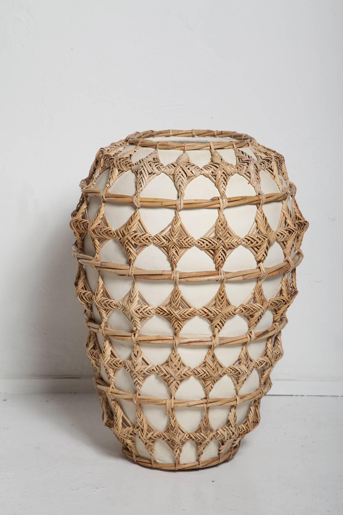 A wonderful, white ceramic floor vase / urn intricately wrapped in woven rattan, a super summer statement piece!