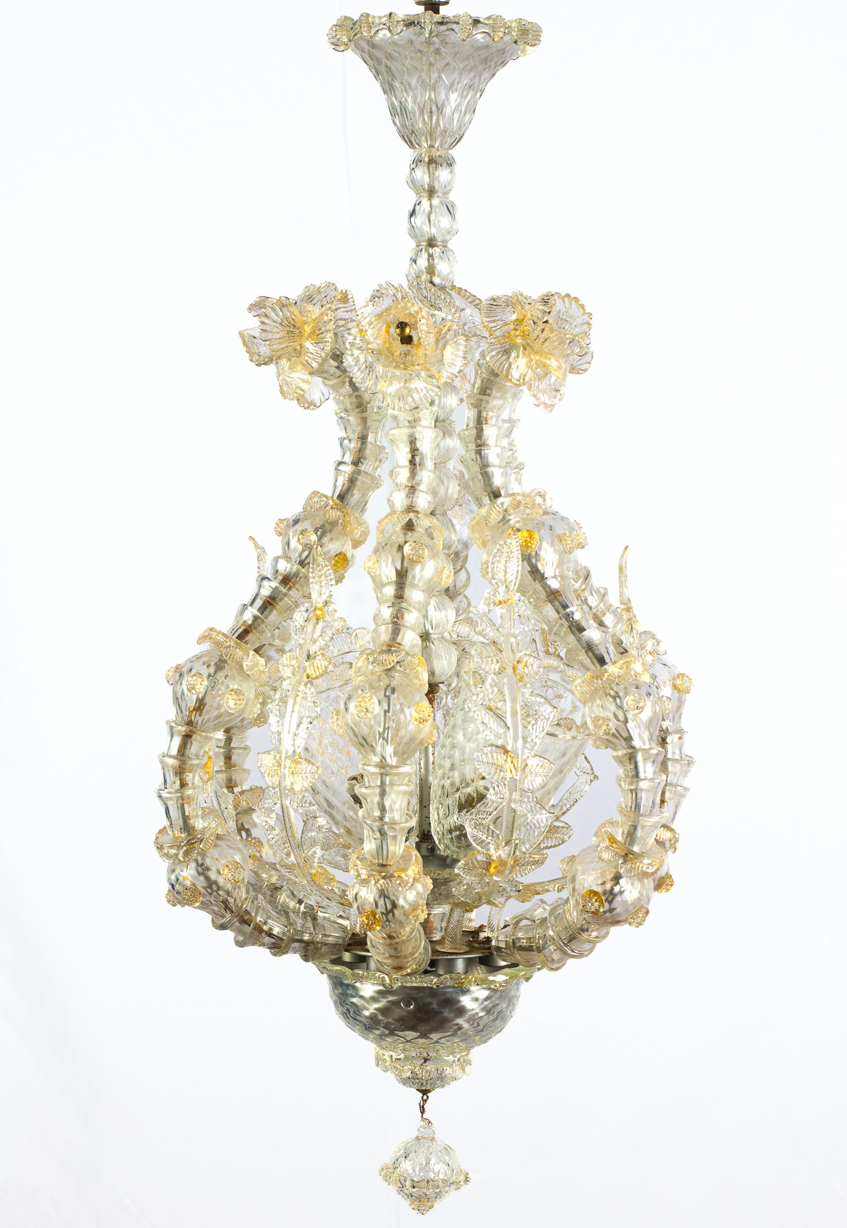 Magnificent pendant with six arms with details gold inclusions. Heads of lions are the ball falls background.
 Centered with three finely handblown cups. Richly decorated with leaves and flowers. 
 The chandelier comes from the private collection