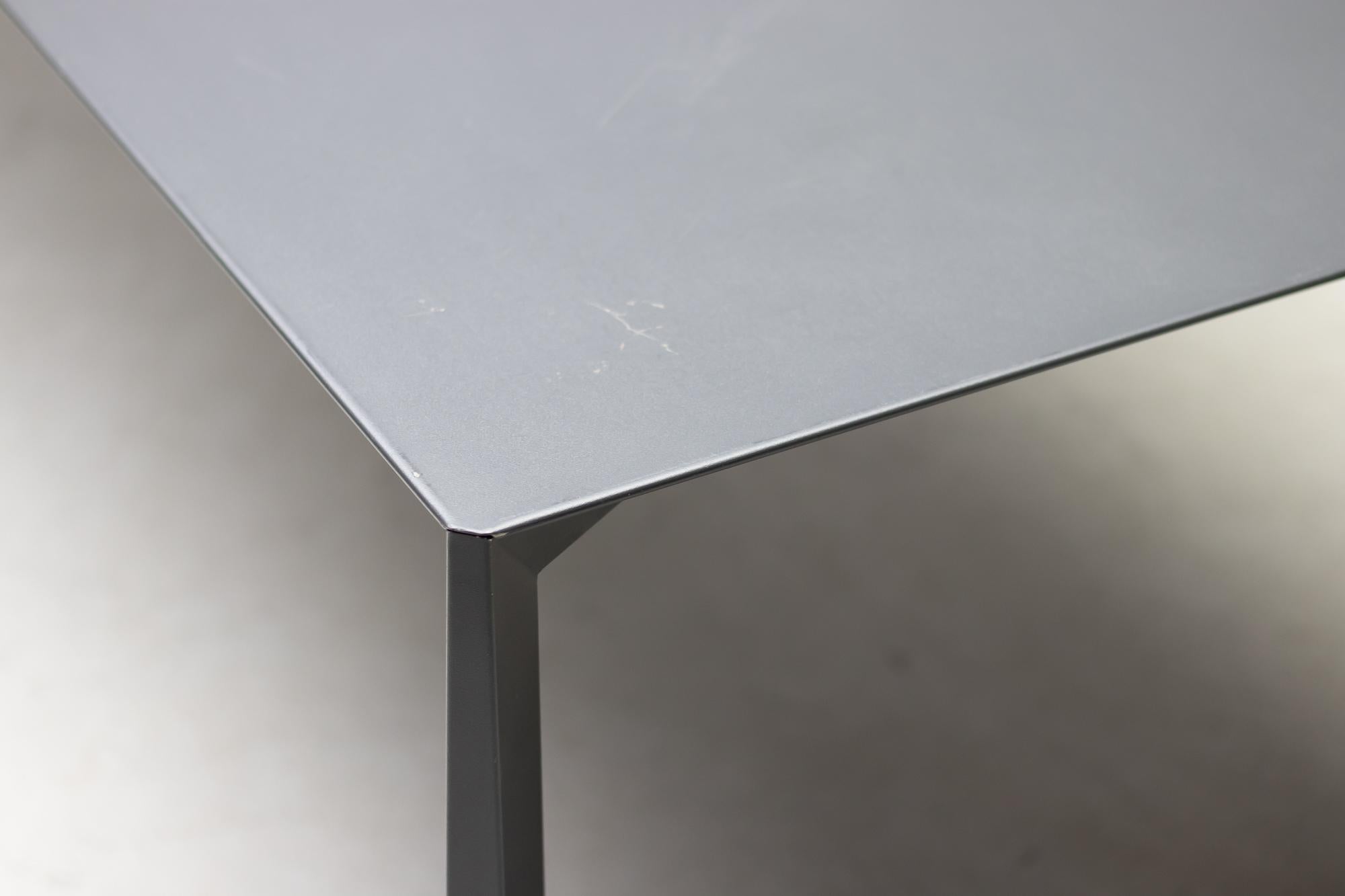 The Ovidio table has a freestanding structure and its geometric form seems to change depending on the point of view.
Large dining or writing table in origami style folded sheet metal, powder-coated in dark grey.
Four tables available, priced