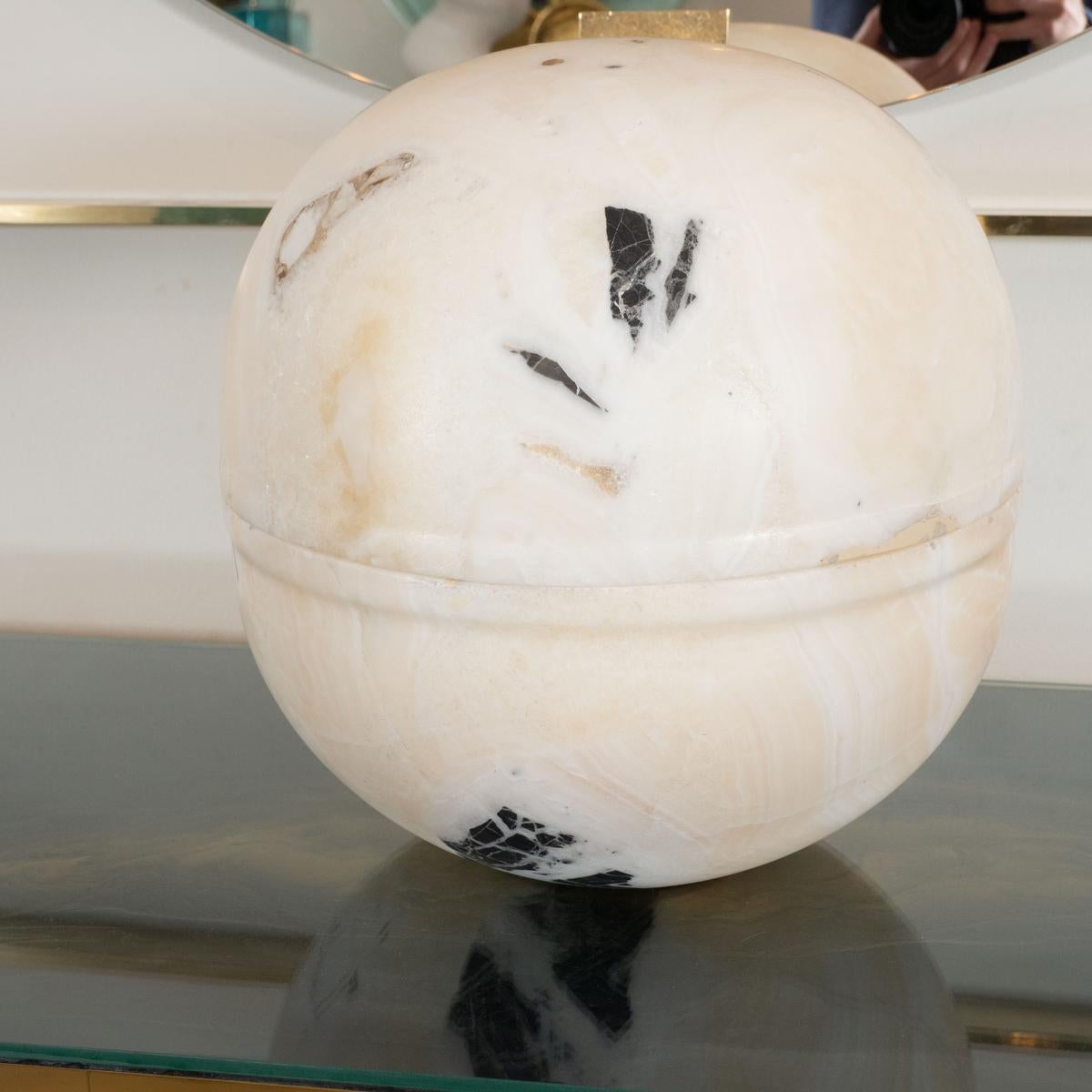 Ovoid marble object with removable top for storage.