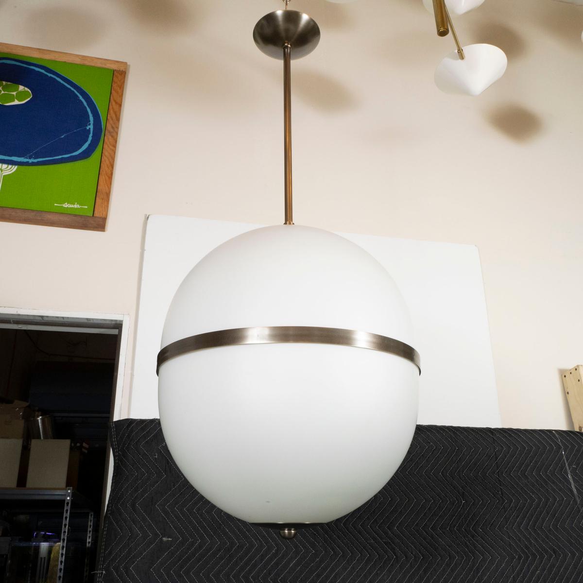 Suspension composée de verre opalin formant un abat-jour ovoïde par Spark Interior. La finition du métal et la hauteur totale sont personnalisables. Veuillez vous renseigner pour plus de détails car le prix peut varier en fonction des