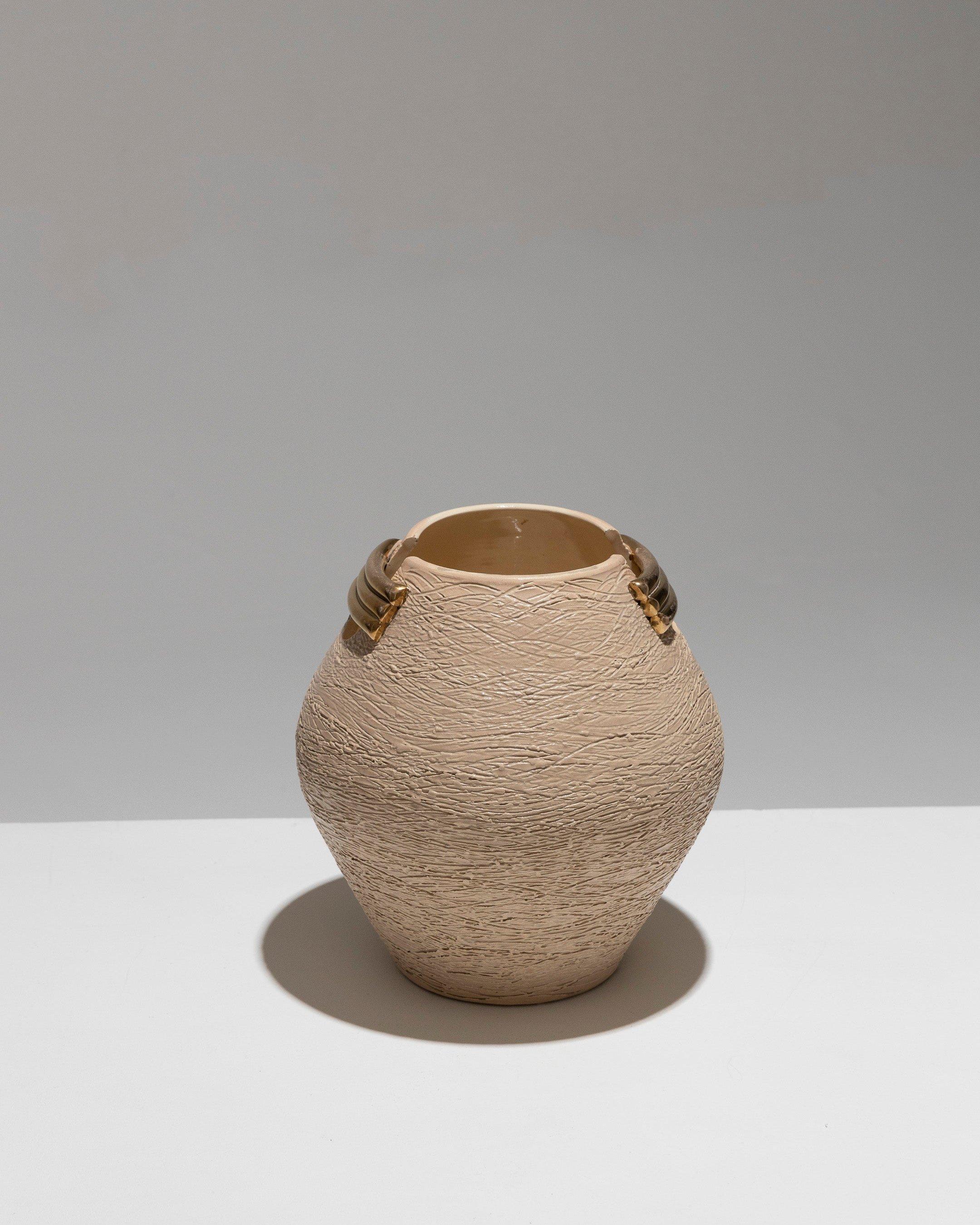 Vase ovoïde en faïence, creusé des deux côtés du corps, années 1940. Orné de trois lingots d'or empilés. Fond blanc rosé doux avec des motifs ondulés gravés dans l'argile. Très bon état.
DV1542