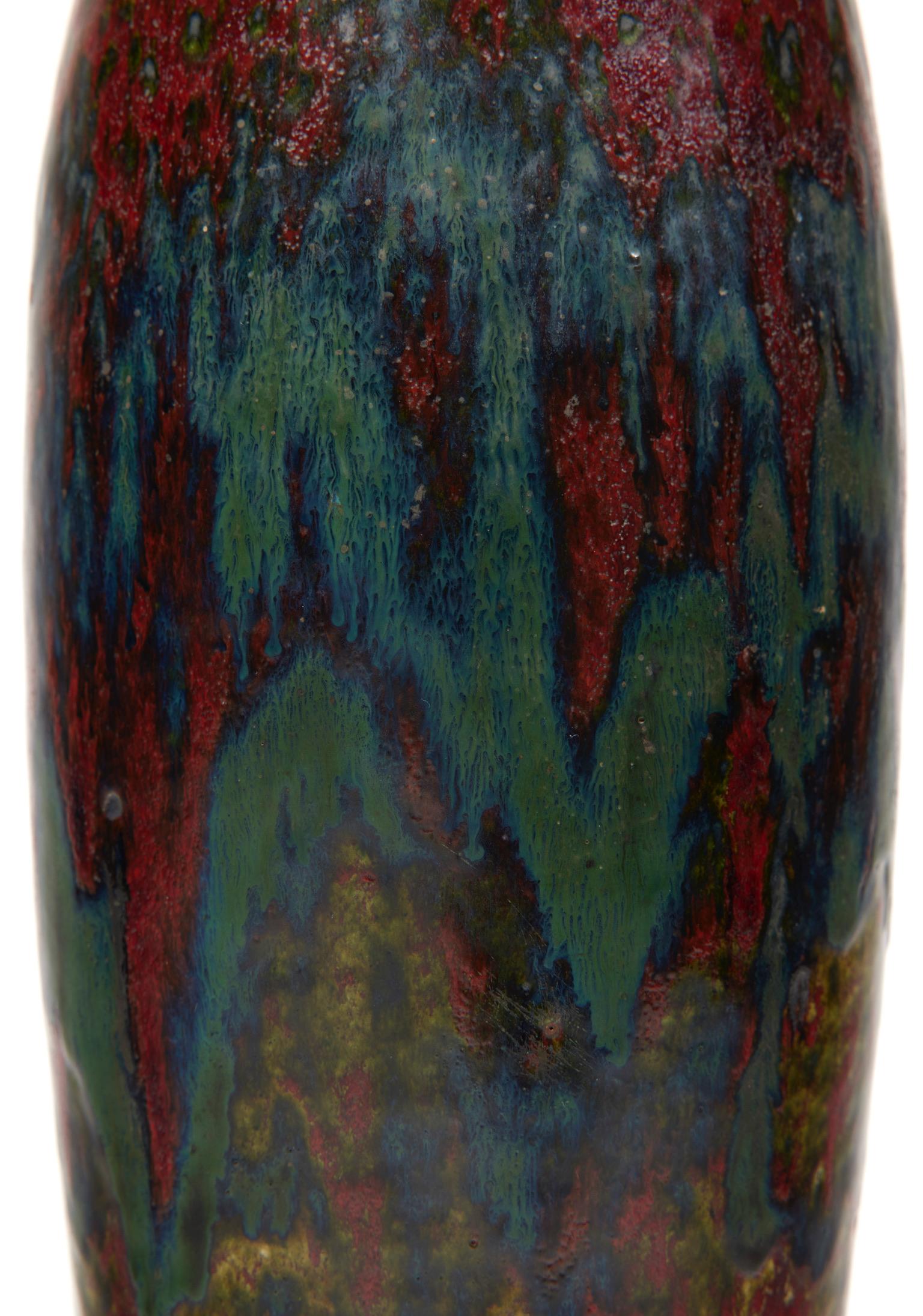 Ovoid stoneware vase with hemmed neck, oxblood red, green and blue enamel.

Signature of a stamp in hollow 